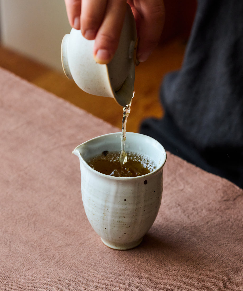Cup of brewed Ancient Wild White showing pale liquor from wild pu'erh trees
