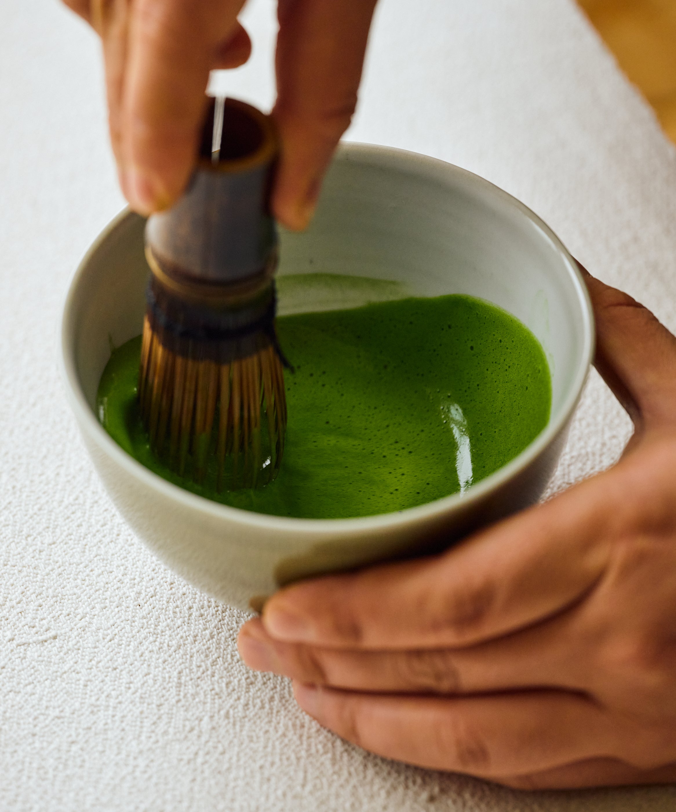 Hand whisking Matcha Yamekaze Japanese matcha with bamboo chasen