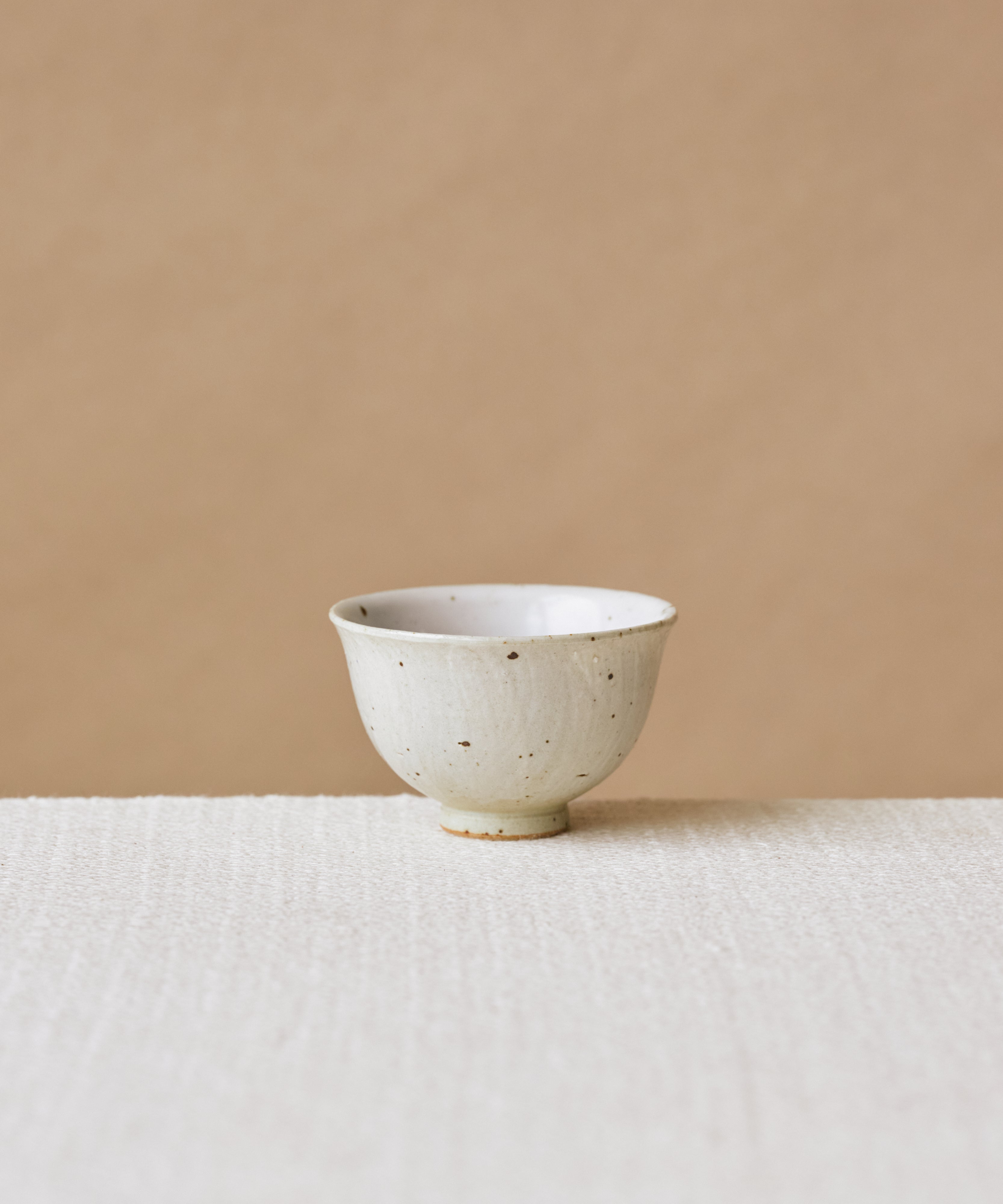 Rock Cup, handcrafted tea cup by Wang Xinghua, Jingdezhen, matte cement surface with copper kiln spots