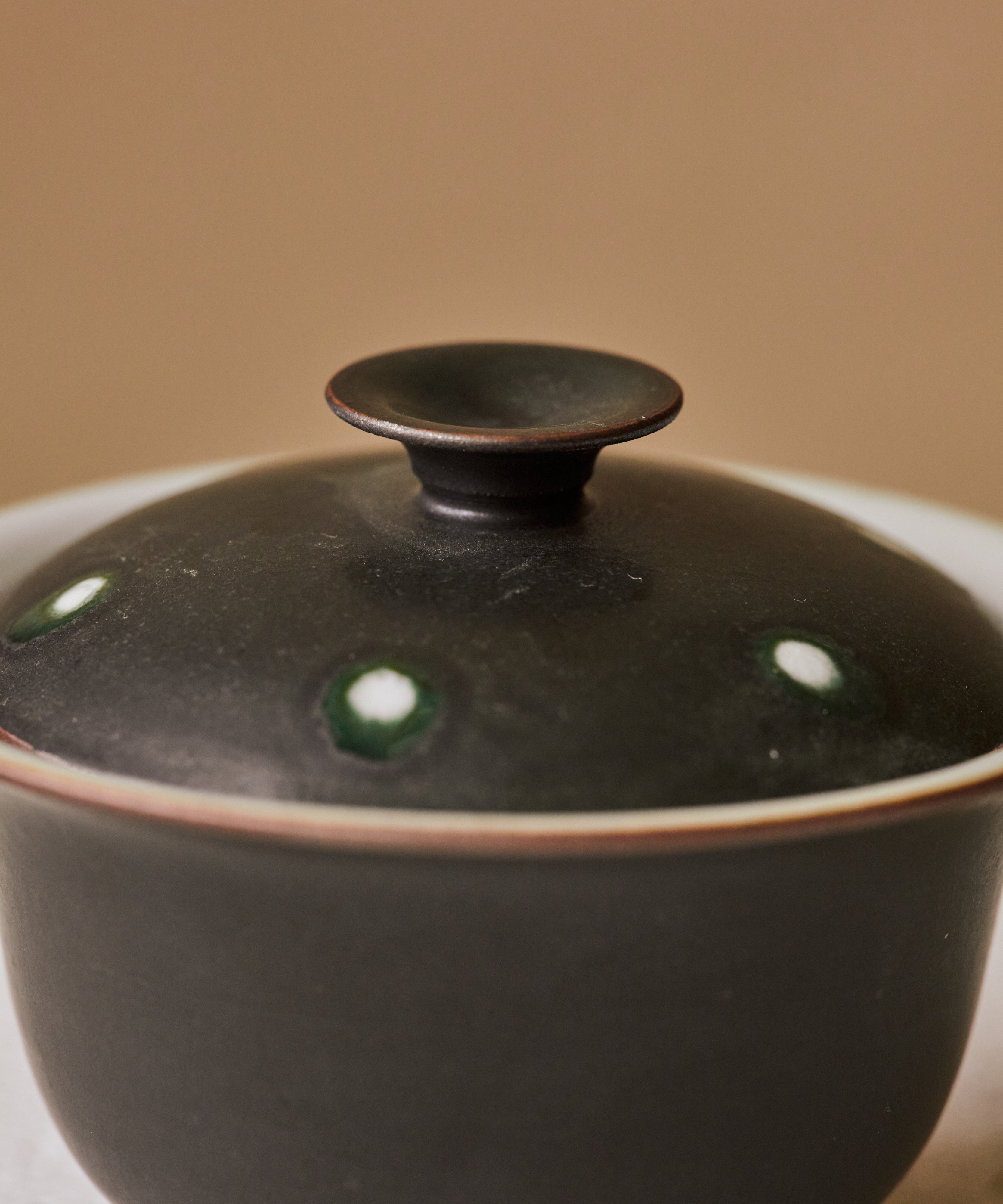 Gaiwan Black Peacock lid detail, matte black glaze with peacock-feather markings, Jingdezhen porcelain