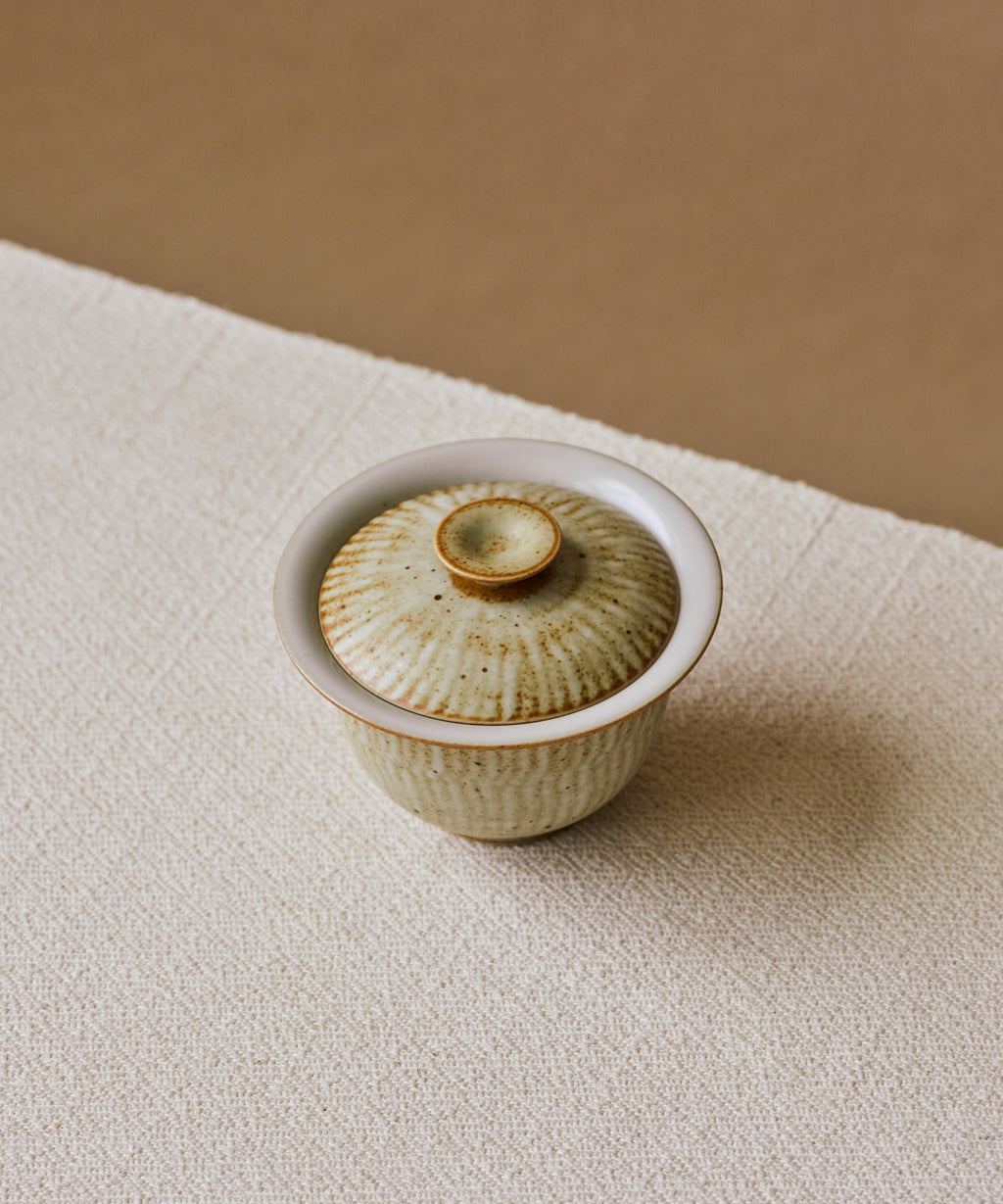Ecru Seashell Gaiwan in hand, bleached and sun-burnished seashell surface, Wang Xinghua gongfu teaware