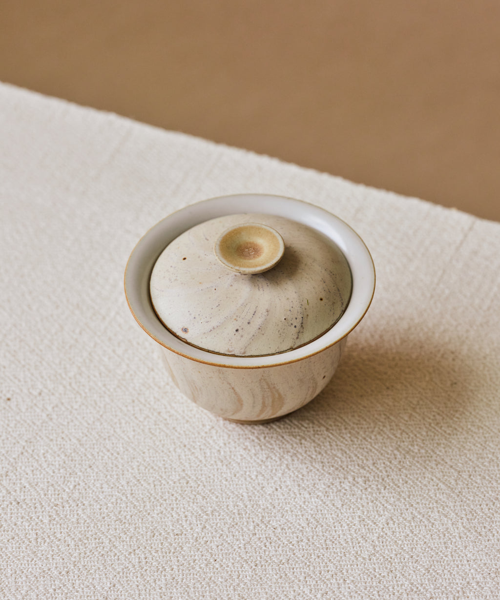 Matte Blush Gaiwan in hand, matte pink glaze with curving sandy strokes, Wang Xinghua gongfu teaware