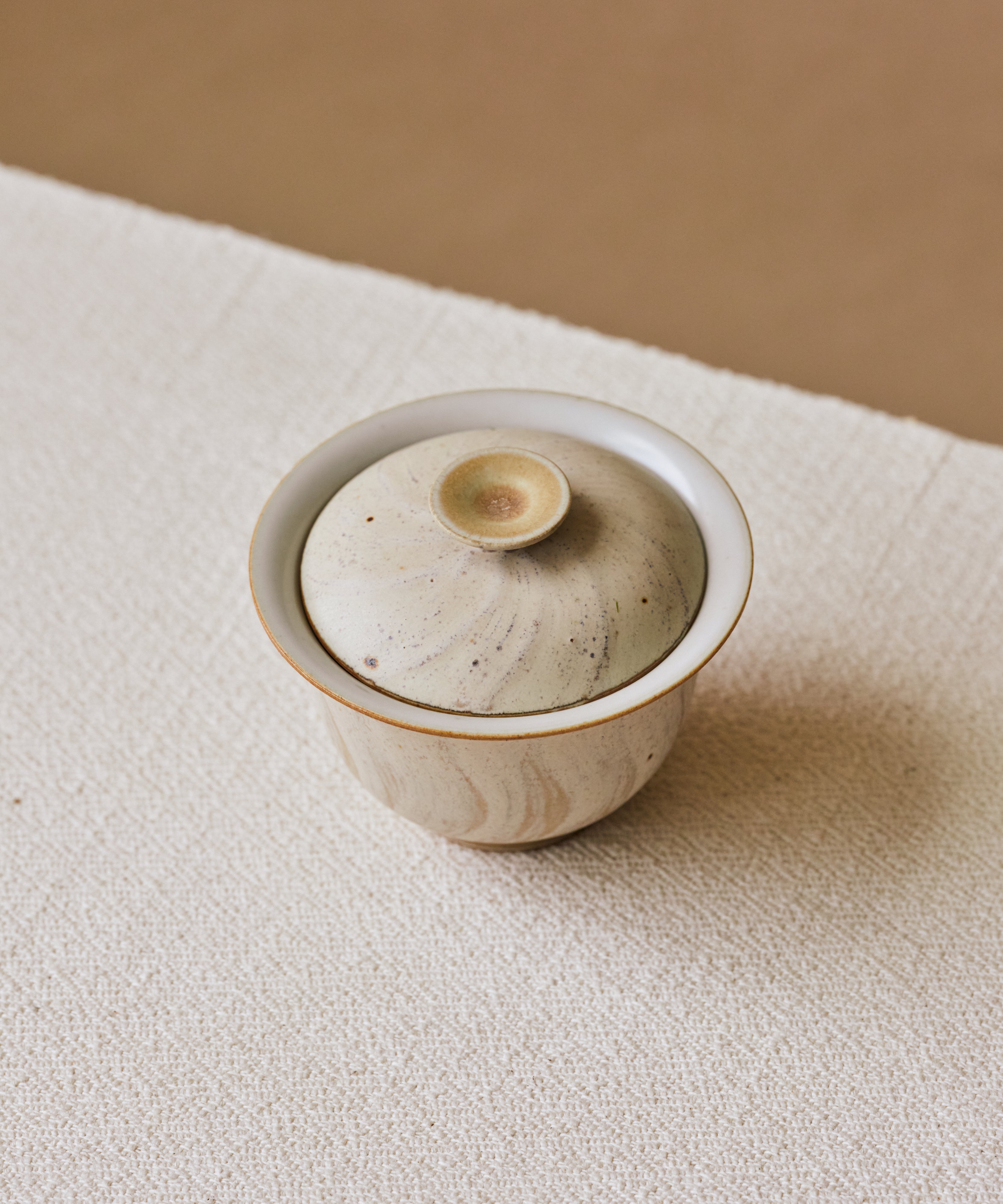 Matte Blush Gaiwan in hand, matte pink glaze with curving sandy strokes, Wang Xinghua gongfu teaware
