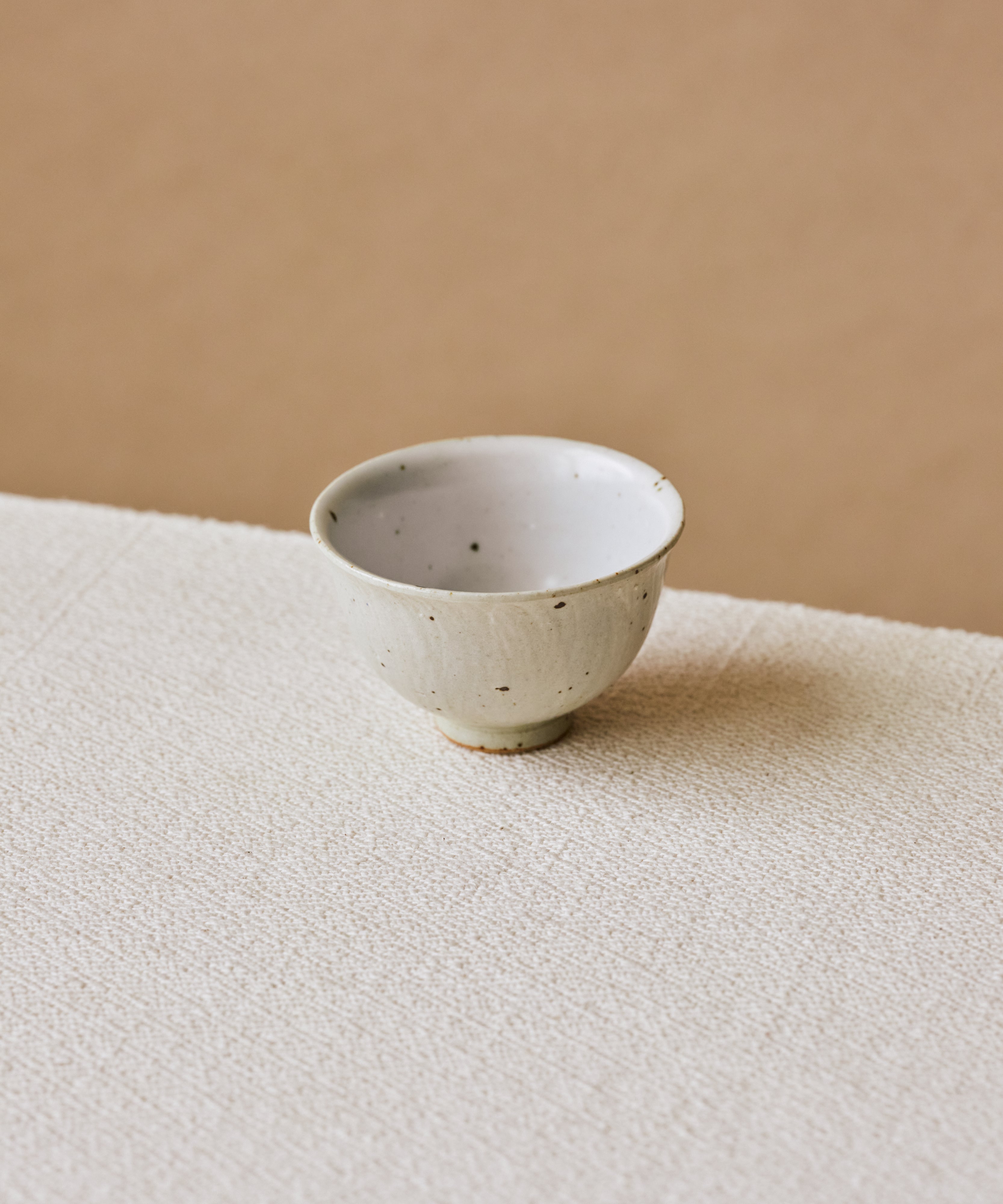 Rock Cup in hand, sage green striations on textured surface, Wang Xinghua gongfu teaware, Jingdezhen