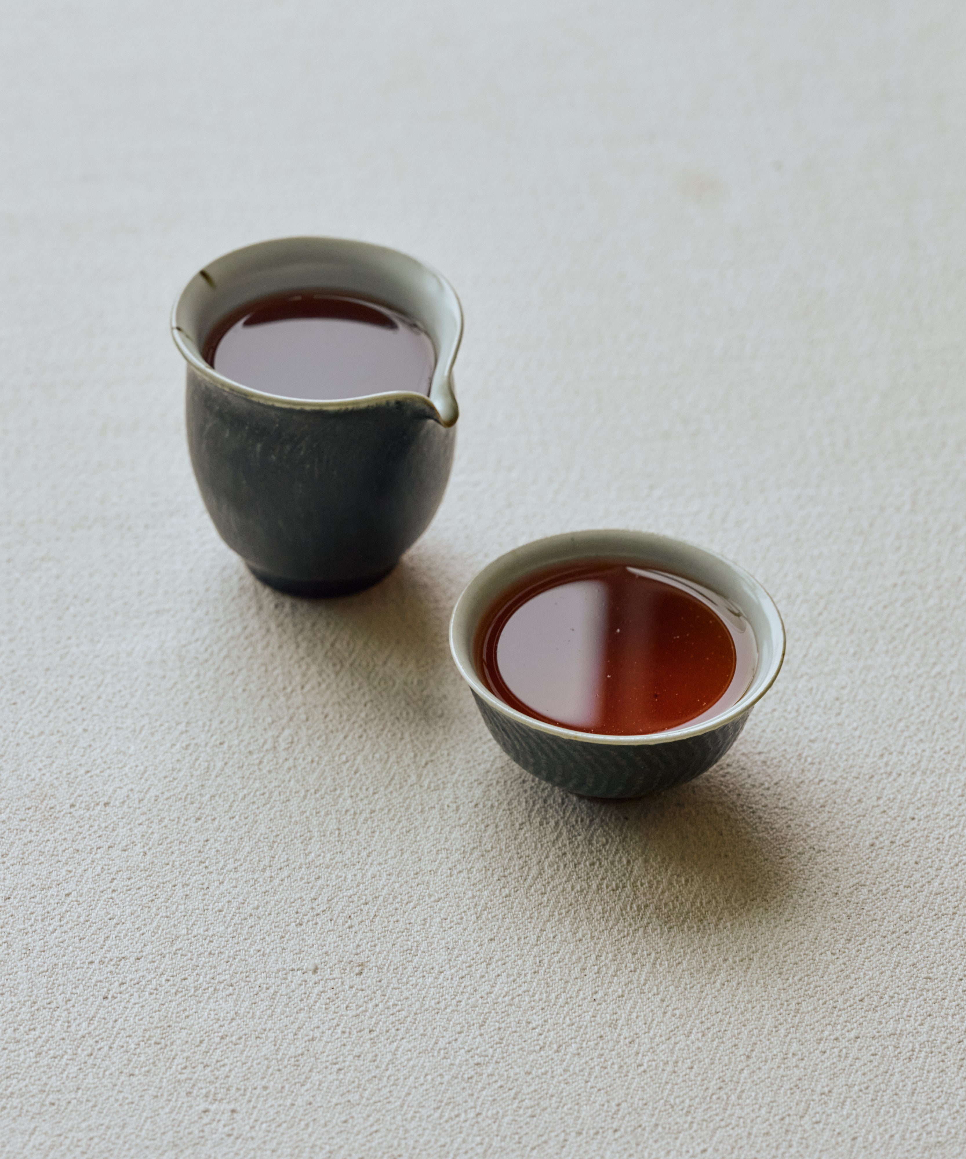 Cup of Jasmine Tibetan Tea showing amber liquor with jujube and cakey notes