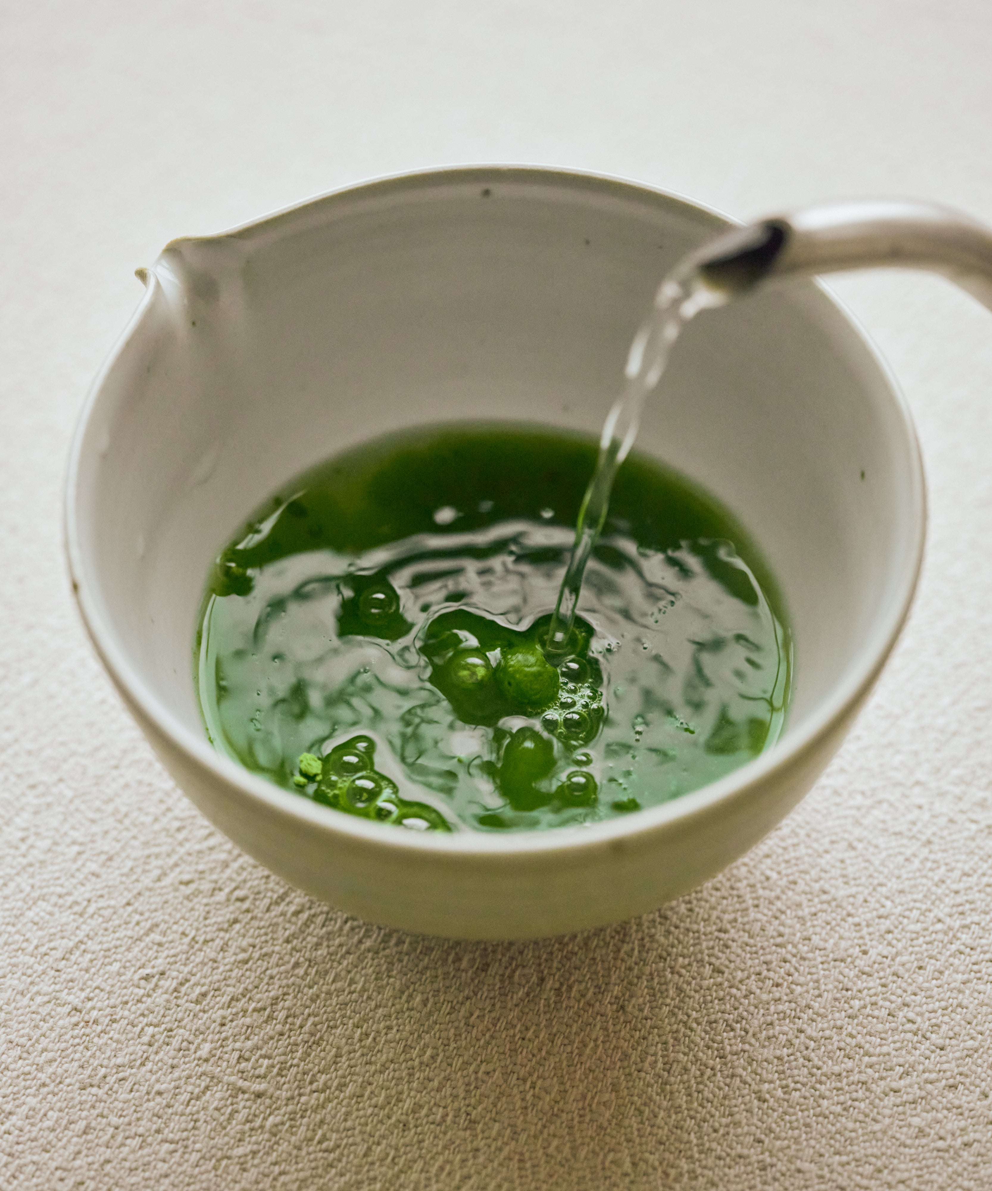 Whisking Genmaicha Matcha with bamboo chasen — spring green foam with toasted rice aroma