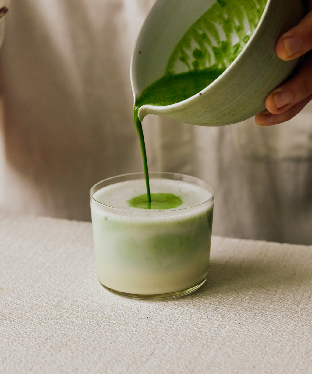 Pouring Genmaicha Matcha latte into glass — toasty, savoury matcha and genmai with oat milk