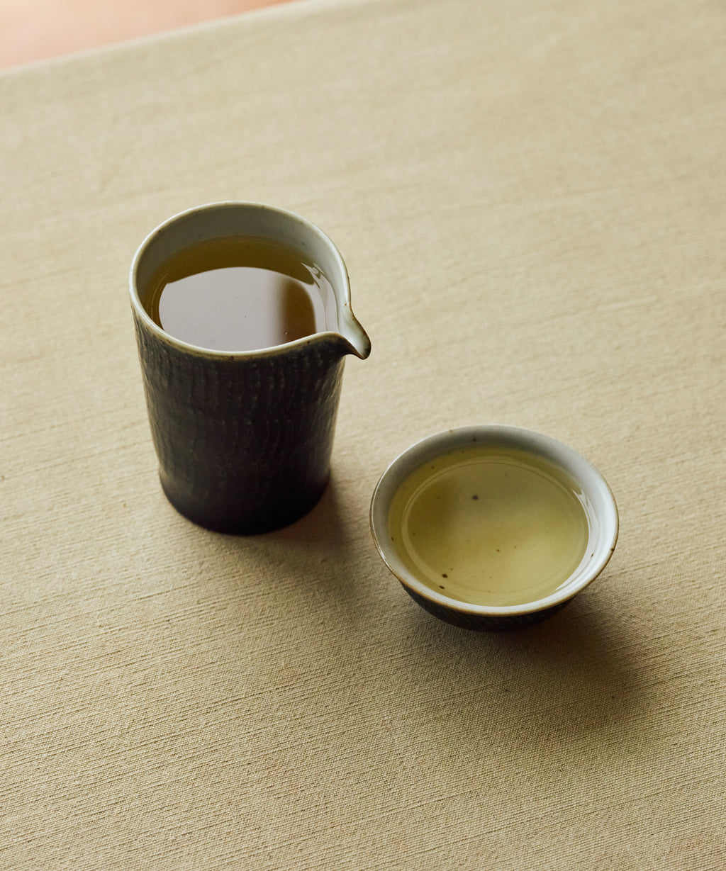Brewed White Moonlight poured into a cup showing pale golden liquor
