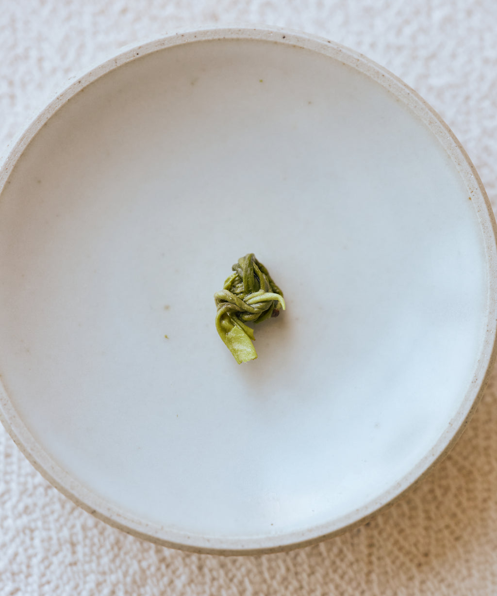Huoqing Fire Jade brewed liquor in glass — deep, complex green tea that drinks like a pu'erh