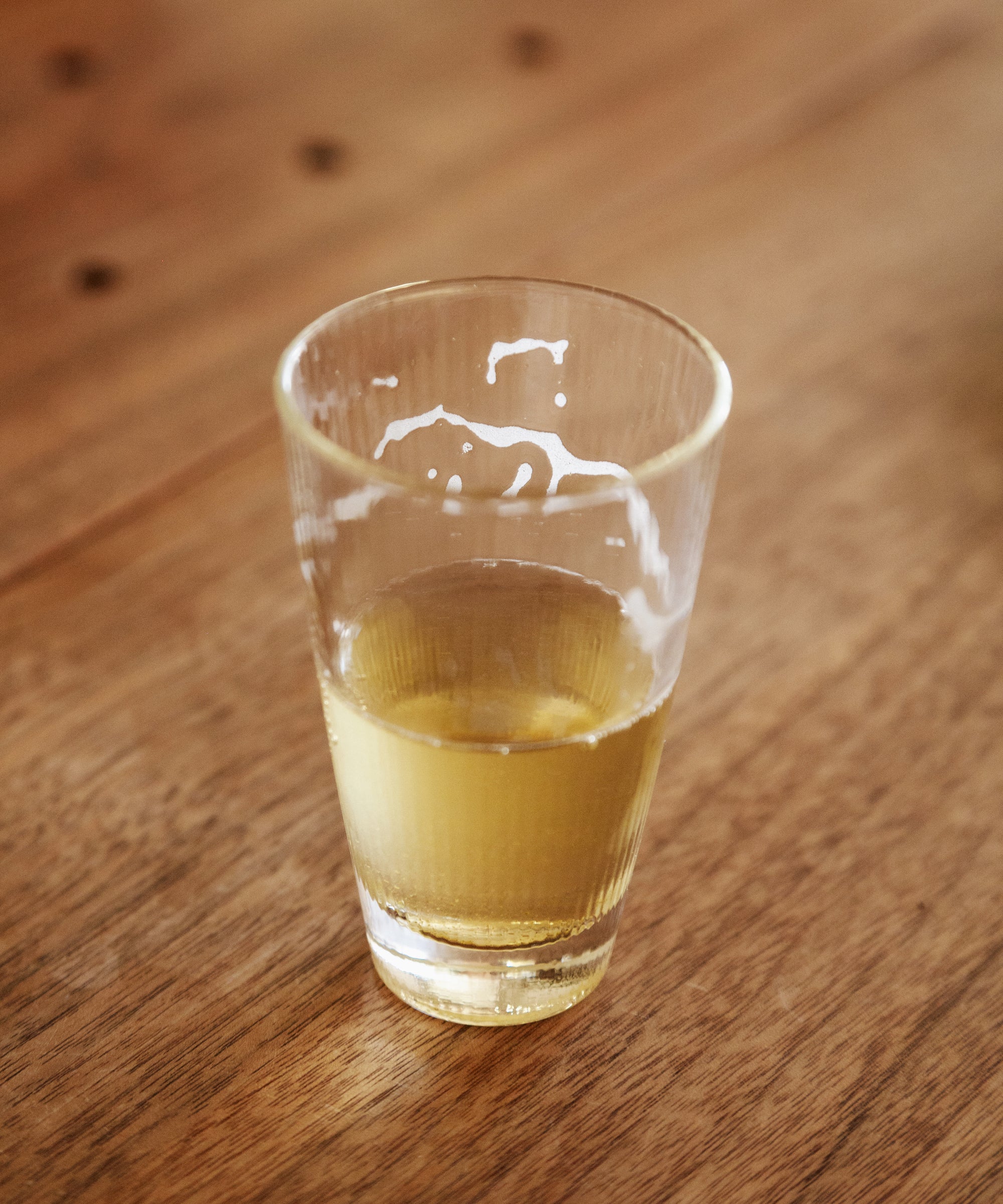 Glass of brewed Noma Koshun sparkling hojicha showing pale golden liquor