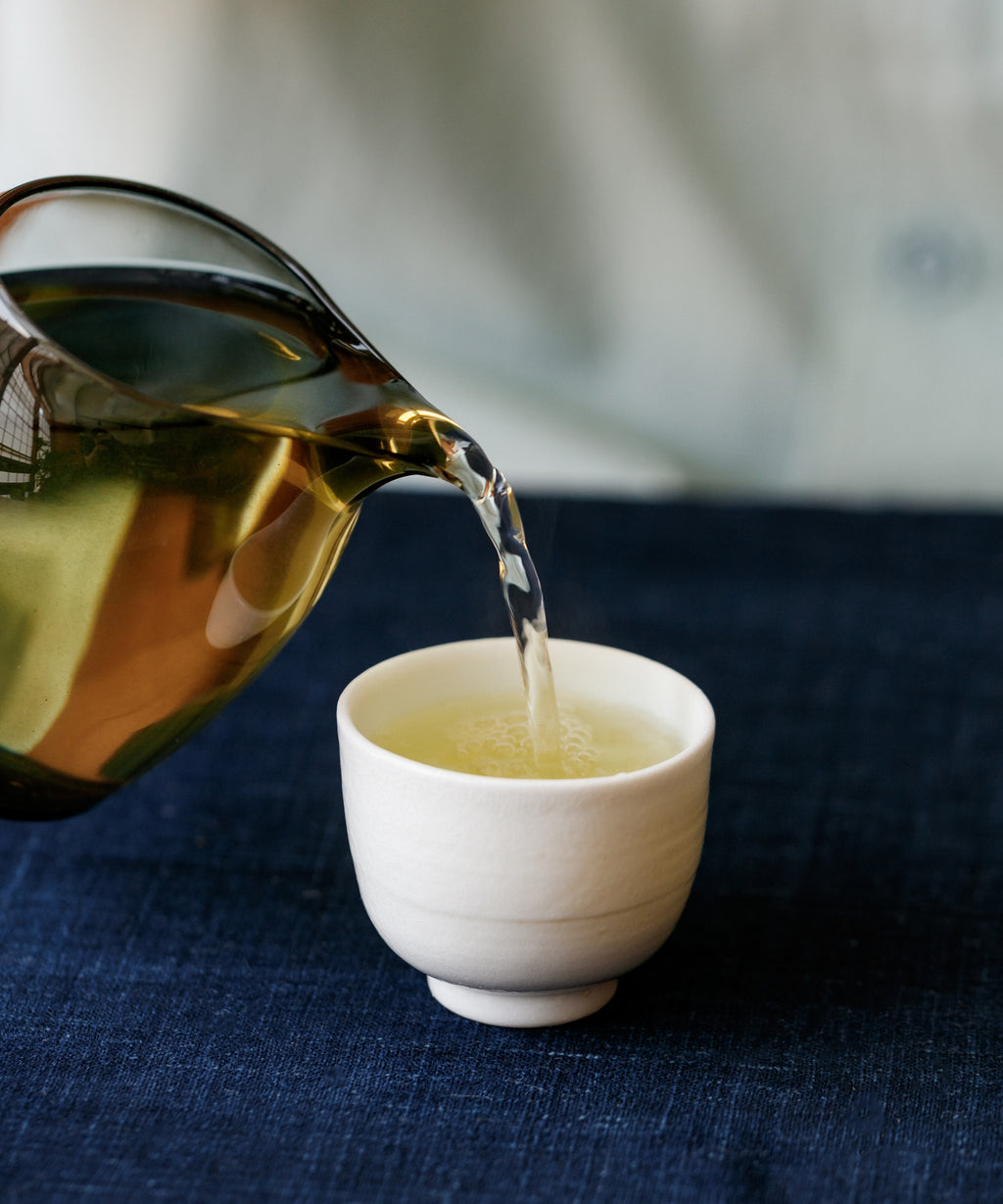 Brewed Pine & Moon sheng pu'erh poured from a gaiwan into a cup