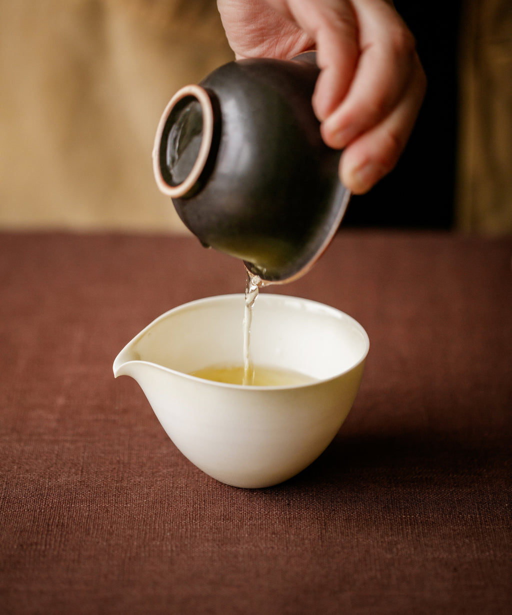 Pouring Alishan High Mountain oolong — golden liquor with lilies, rainwater, and alpine tingle