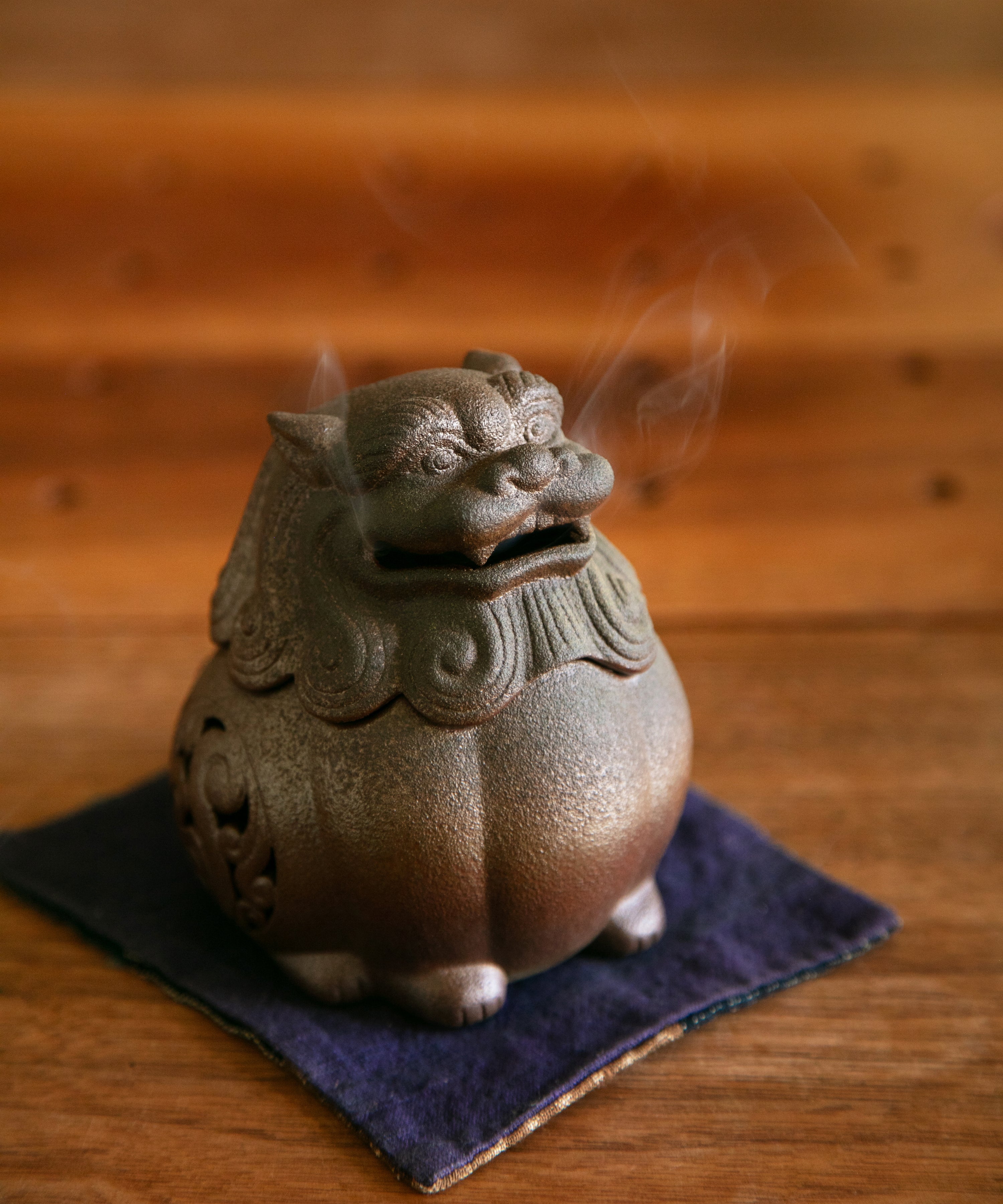 Burnished red clay lion incense burner in a tea space setting