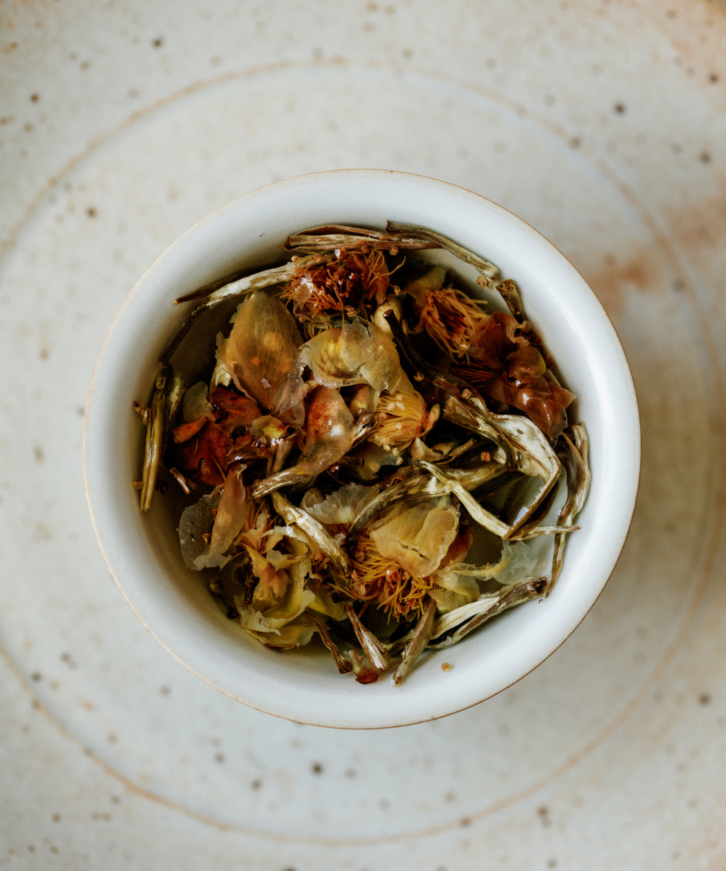 Silver Needle & Tea Blossoms in a vessel ready for brewing