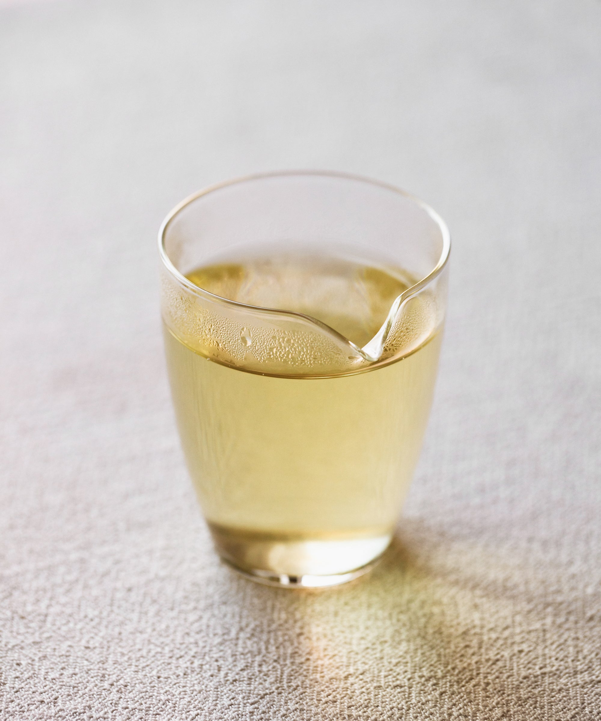 Cup of brewed Jasmine Snow Flake green tea showing pale clear liquor