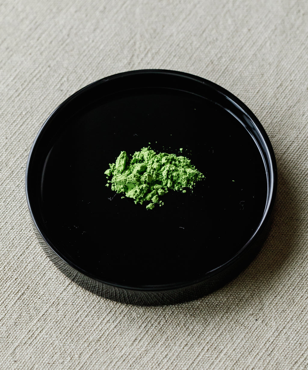 Matcha Kotobuki ceremonial powder on black plate — Arita Sansuien's highest grade Uji matcha, green peas and vanilla