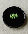 Matcha Kotobuki ceremonial powder on black plate — Arita Sansuien's highest grade Uji matcha, green peas and vanilla