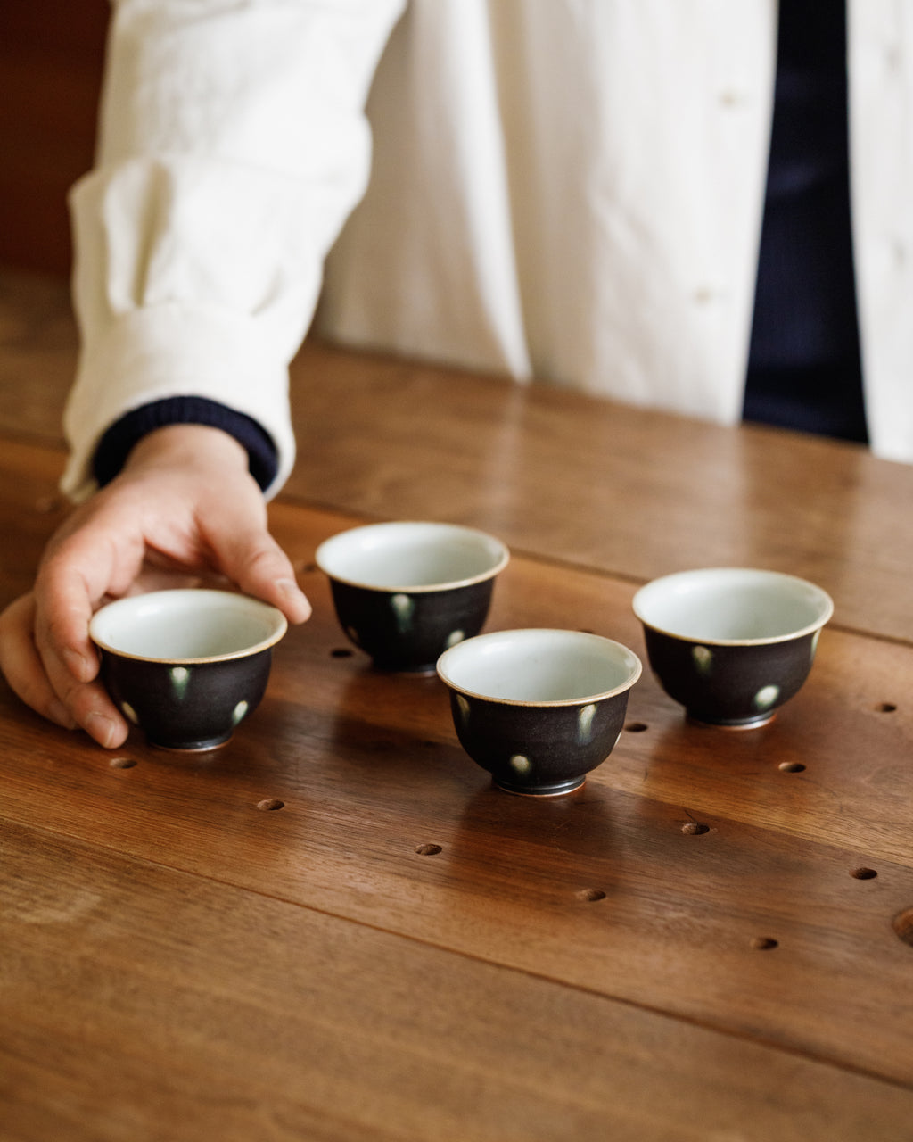Cup Black Peacock detail, green-ringed spots on matte black, handcrafted Jingdezhen gongfu teaware