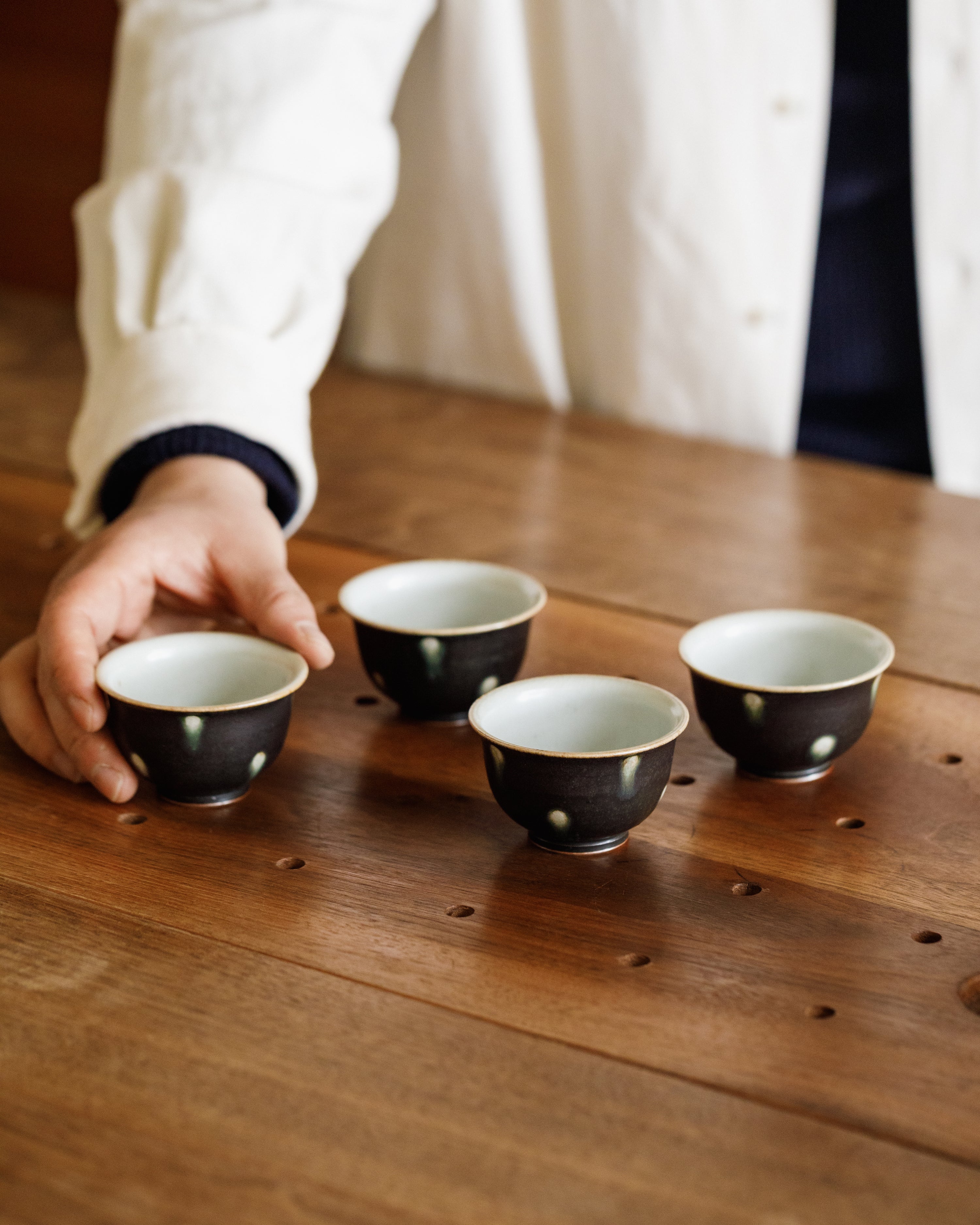 Cup Black Peacock detail, green-ringed spots on matte black, handcrafted Jingdezhen gongfu teaware