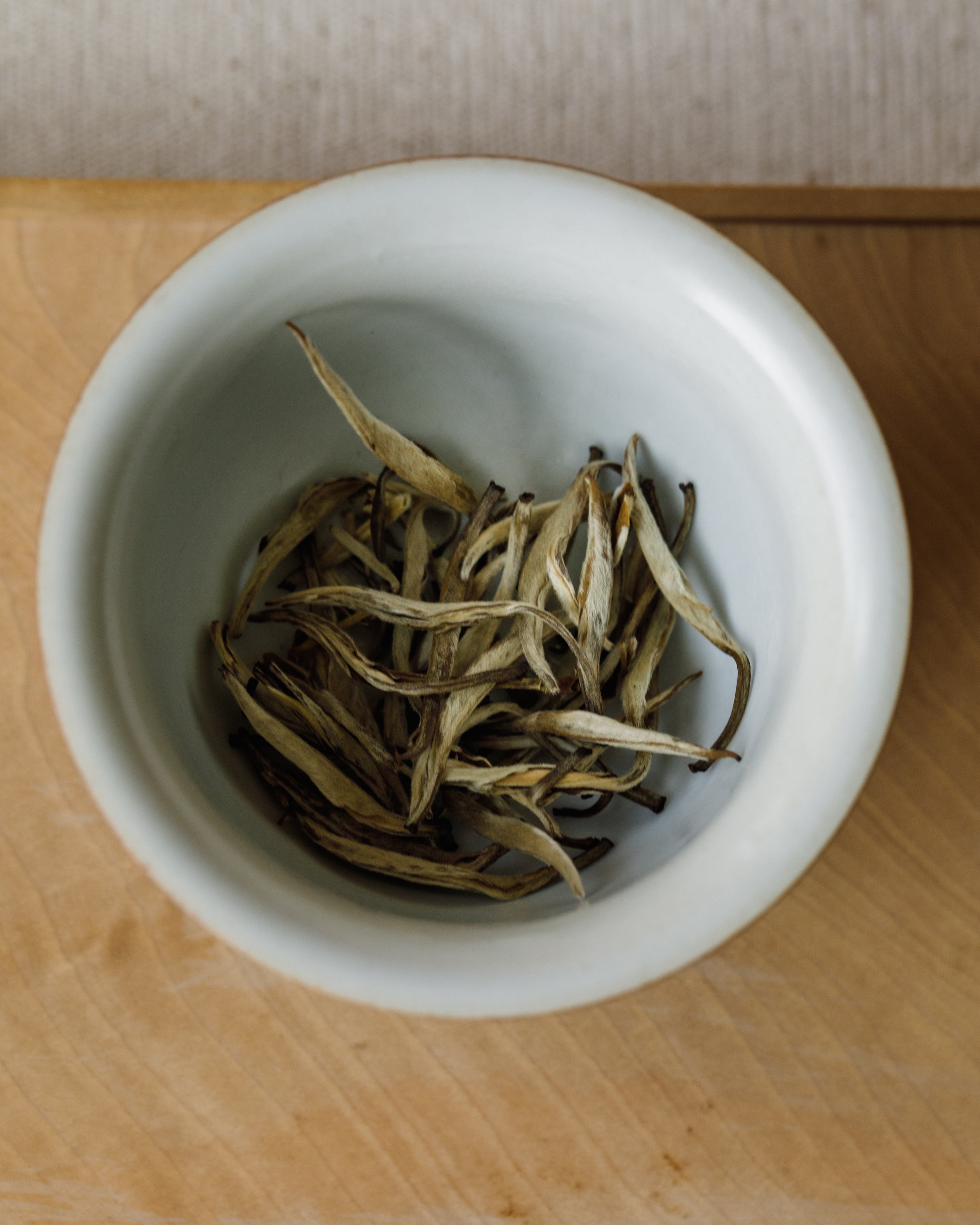 Jasmine Silver Tips in a white porcelain bowl ready for brewing