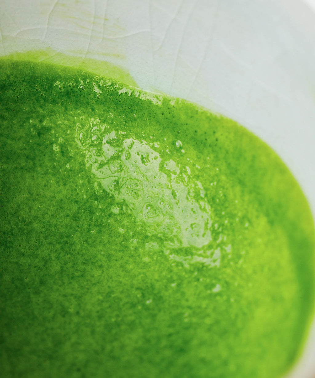 Preparing Kirari matcha latte by whisking in a clear glass
