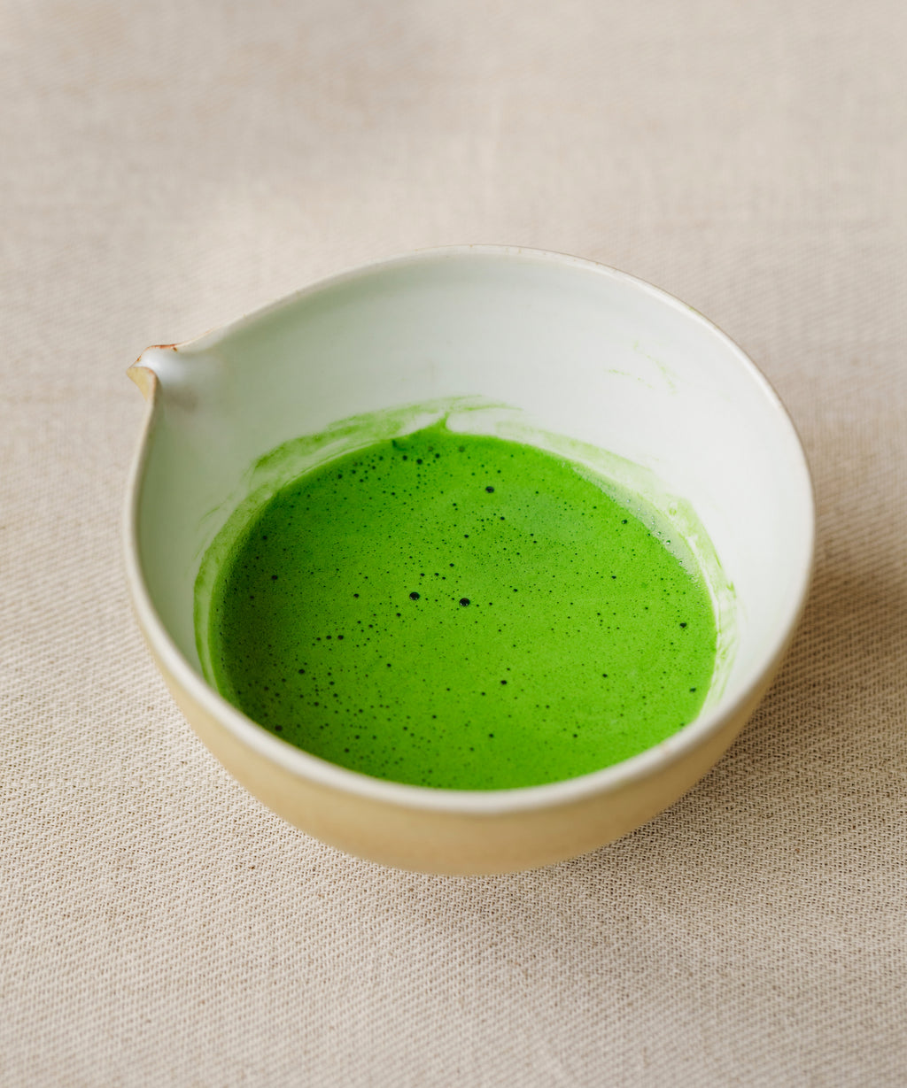 Top-down view of whisked Oku Yutaka usucha showing fine crema and grass-green pigment