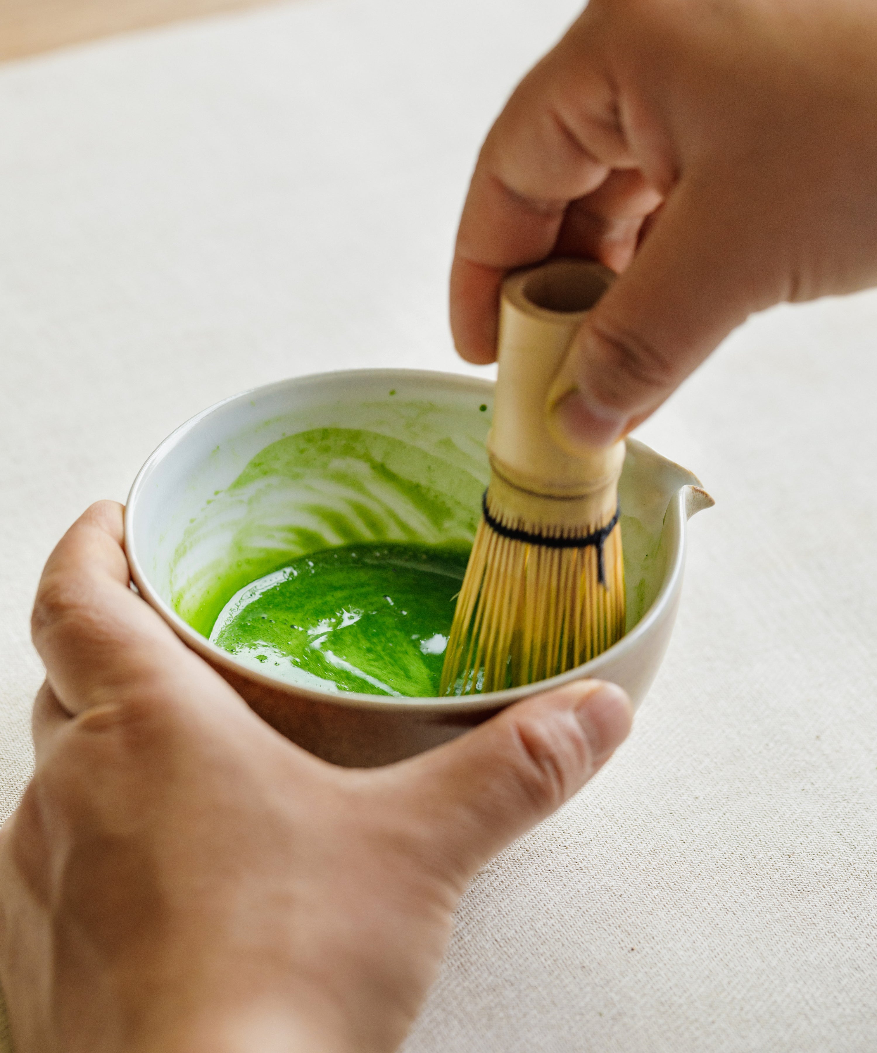 Whisking Ooiwase matcha with a bamboo chasen, showing intense pigment
