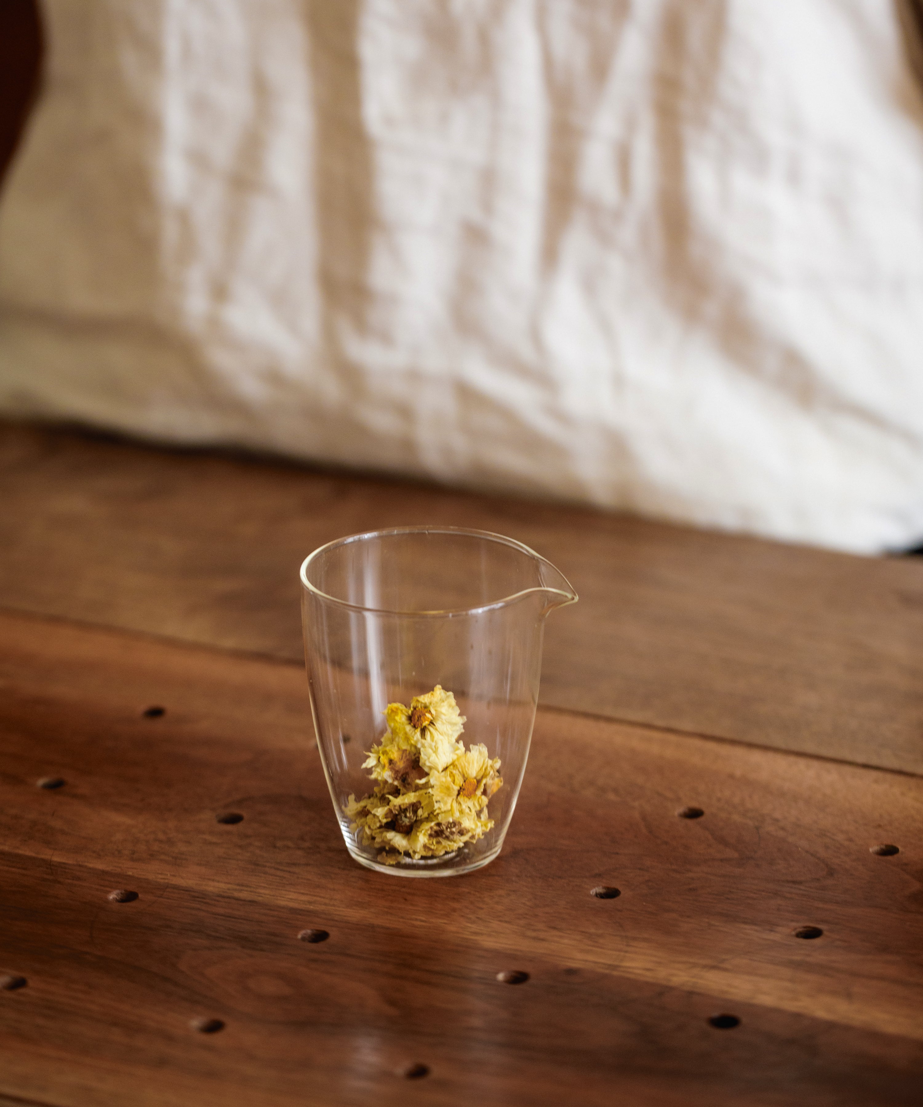 Brewing Silk Chrysanthemum Cake in a glass pitcher, pressed flowers expanding in hot water