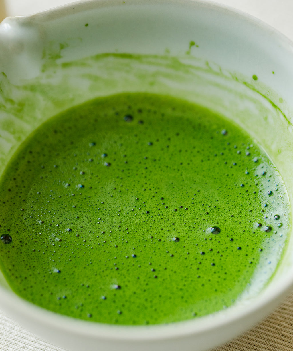 Whisking Saemidori matcha with a bamboo chasen, showing soft asparagus green color