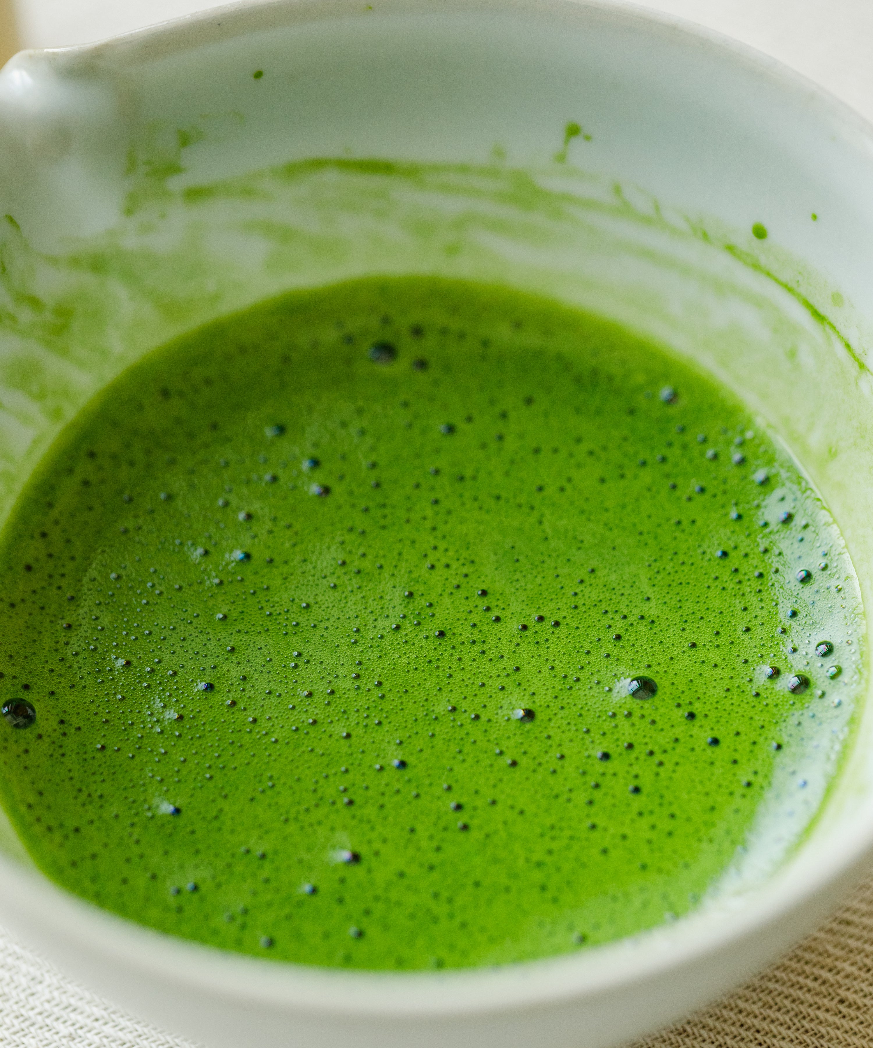 Whisking Saemidori matcha with a bamboo chasen, showing soft asparagus green color
