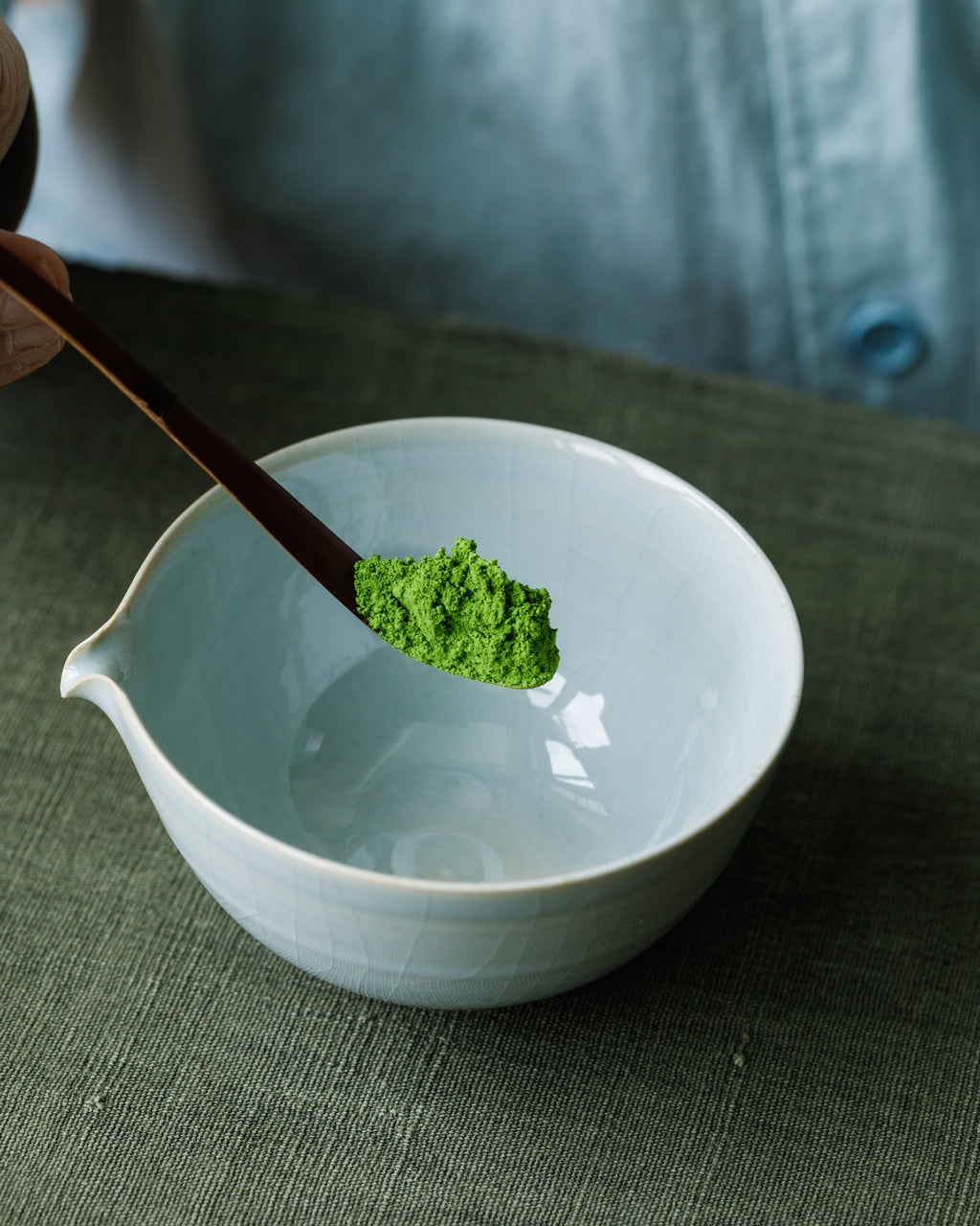 Whisking Matcha Hikari Japanese matcha in white chawan with bamboo chasen