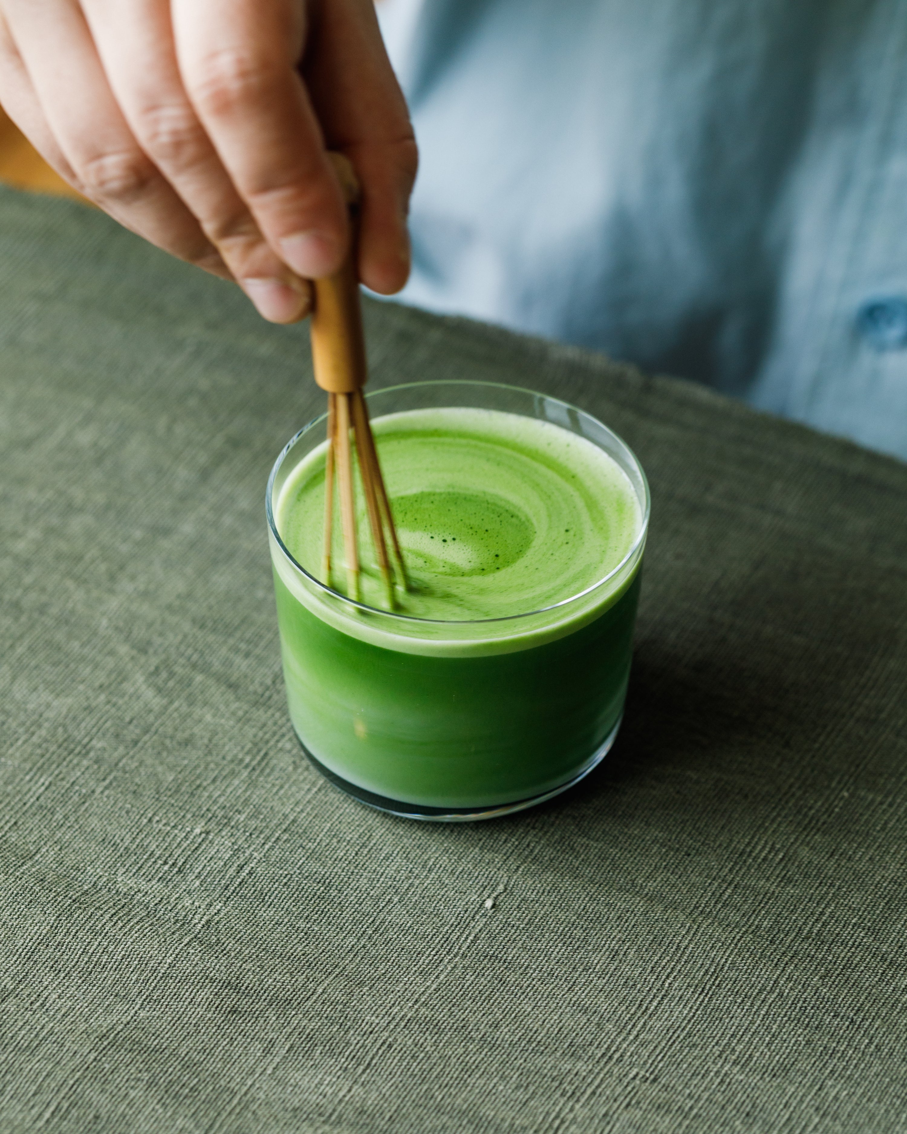 Preparing Matcha Hikari latte with steamed milk in clear glass