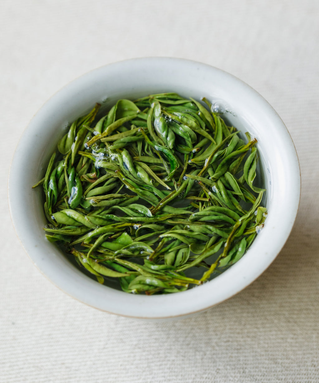 Anji Baicha leaves in a white porcelain bowl ready for brewing