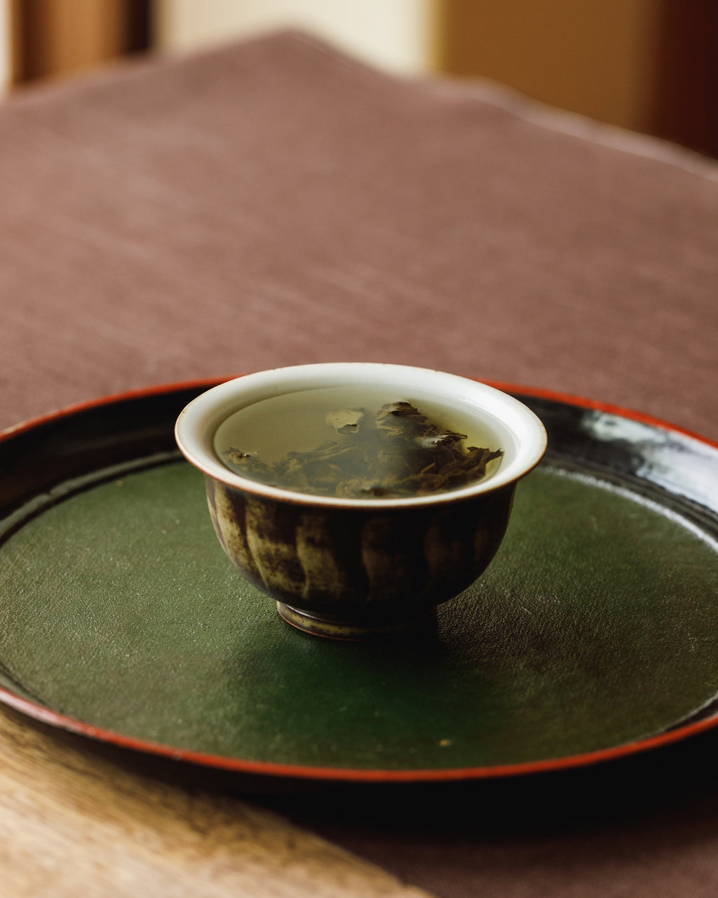 Brewed Autumn Tieguanyin in a cup showing amber liquor with charcoal depth