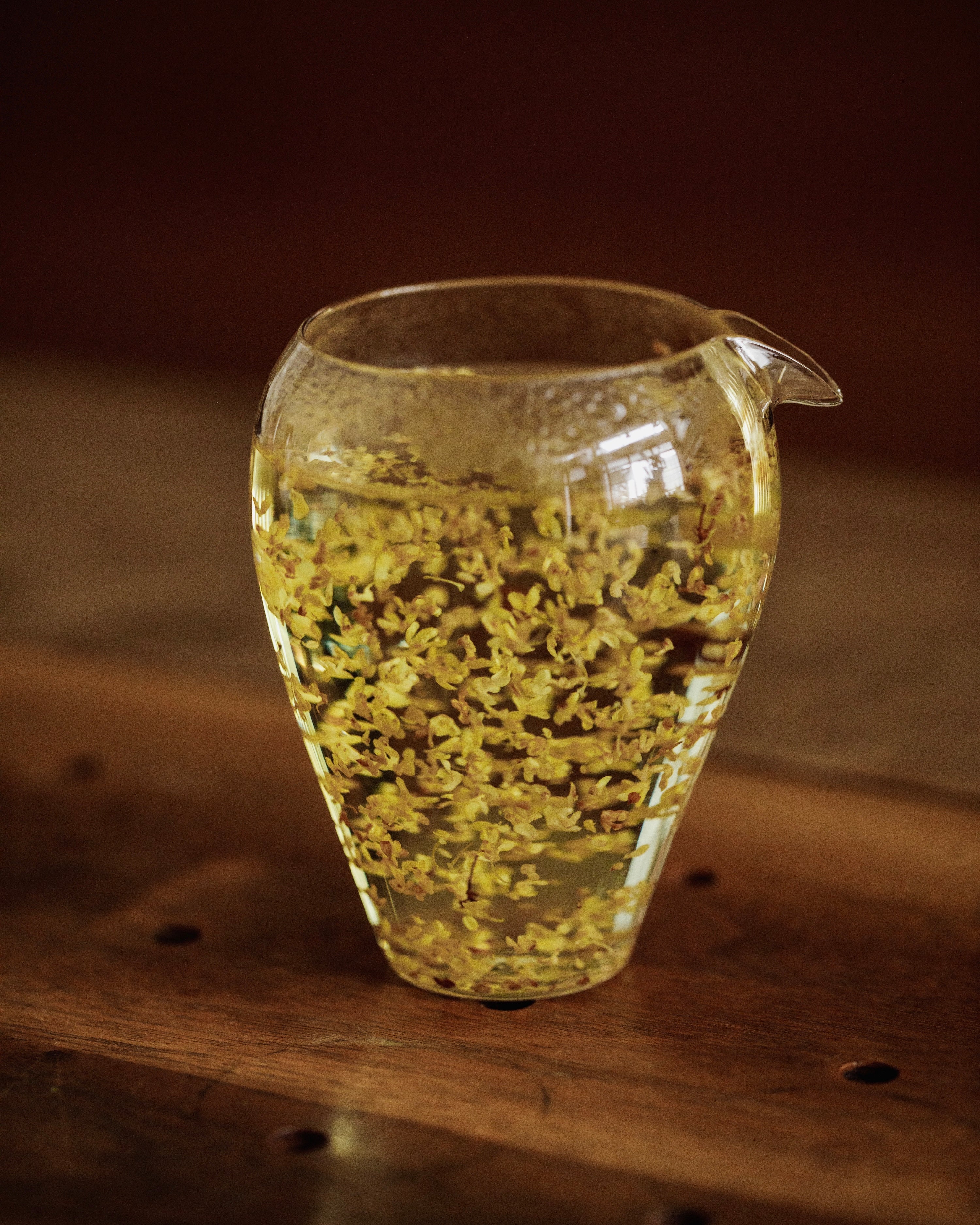 Hot water poured over Gold Osmanthus in a glass vessel