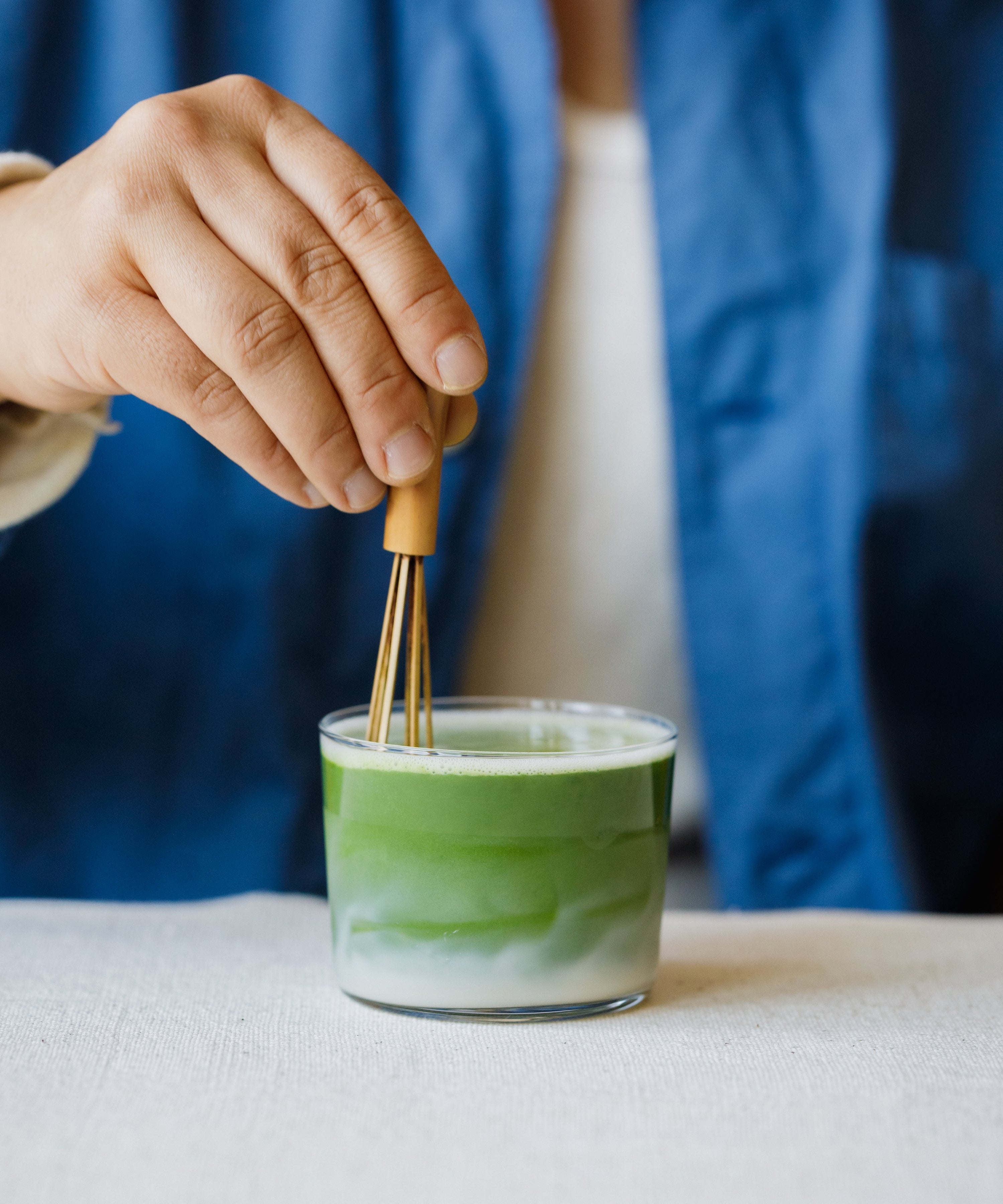 Preparing Tsuyu Hikari matcha latte by whisking in a clear glass