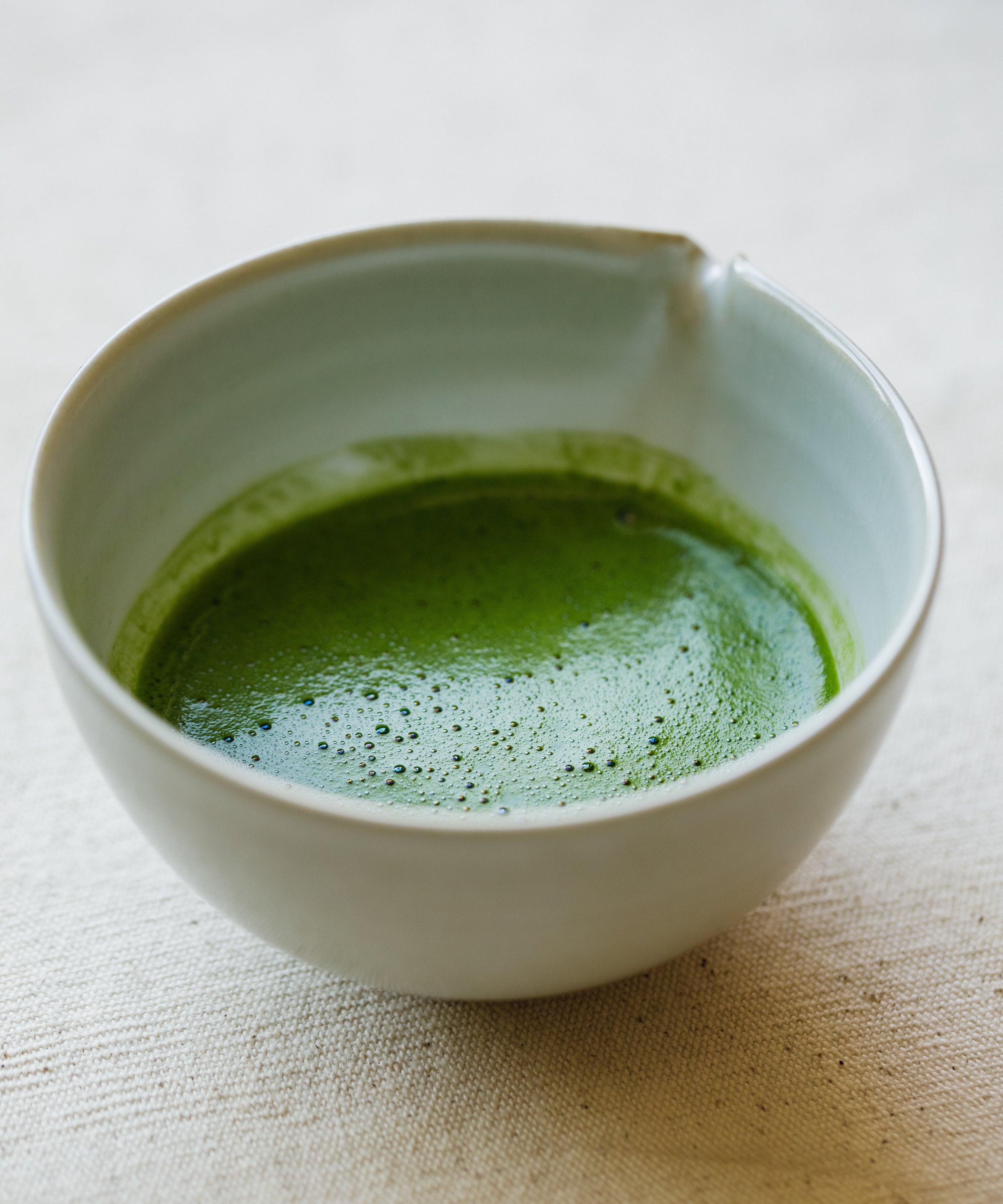 Pouring Seimei matcha into a glass for latte preparation