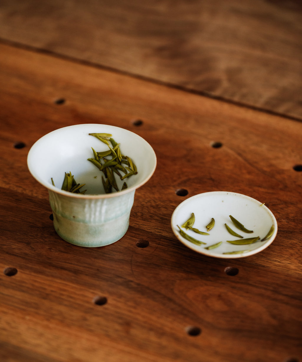 Gardenia Bird's Tongue dry buds scattered — tiny first harvest green tea buds from sacred Mengding Mountain
