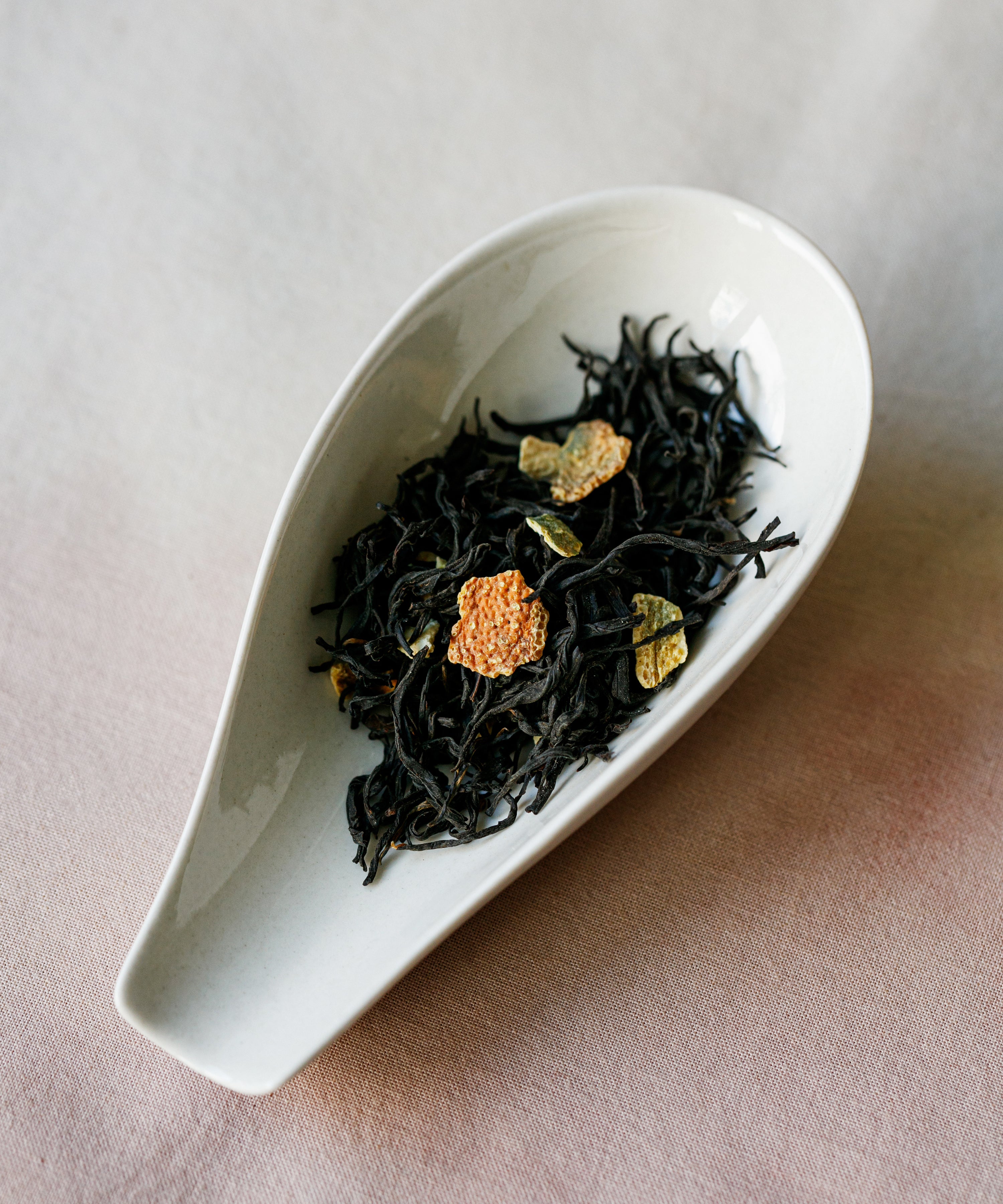 Dry Yuzu & Gold Guanyin showing the curled black tea leaves and dried Chinese yuzu peel