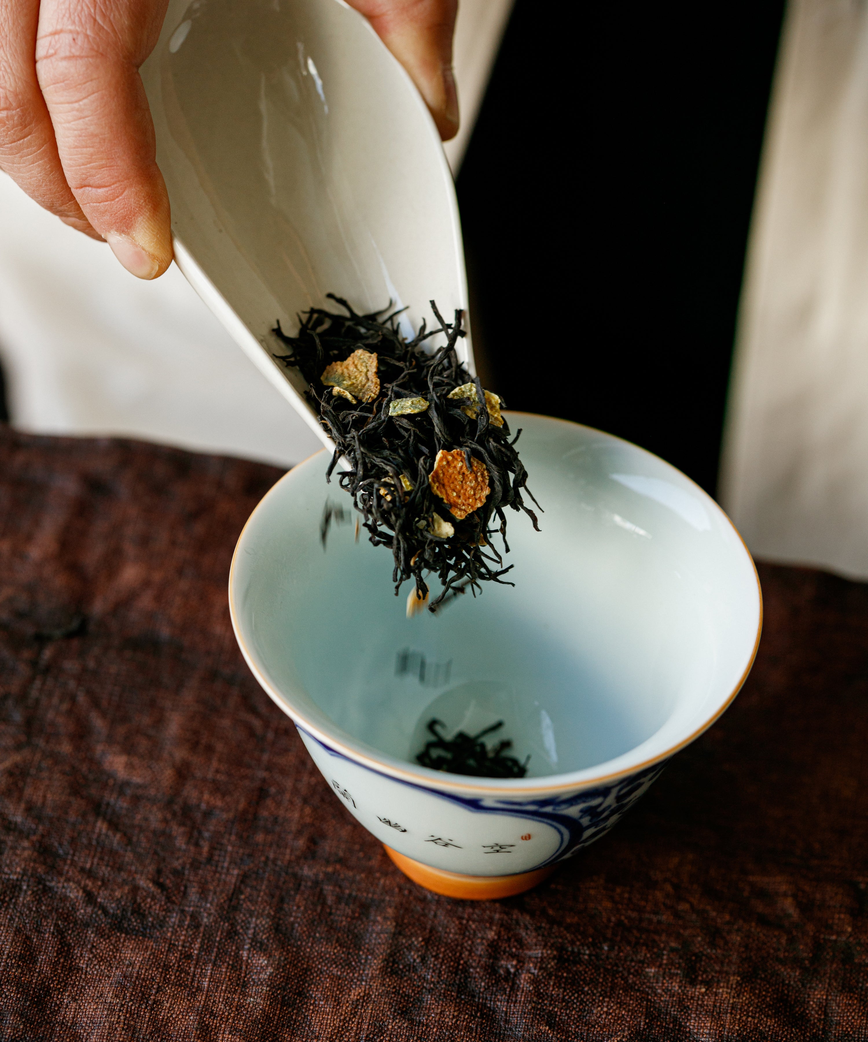Yuzu & Gold Guanyin leaves in a white porcelain gaiwan ready for brewing