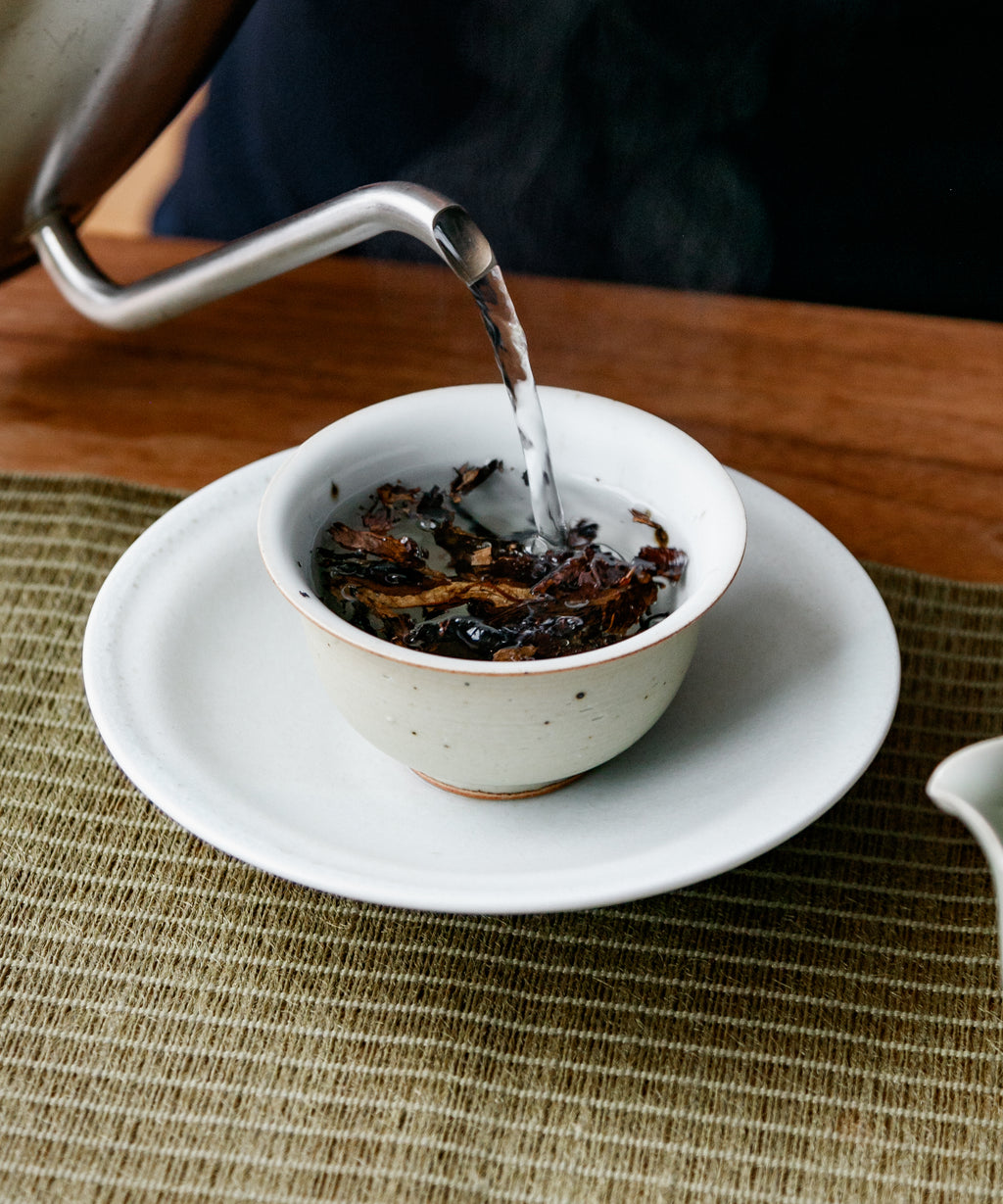 Purple Cloud white tea leaves in a white vessel ready for brewing