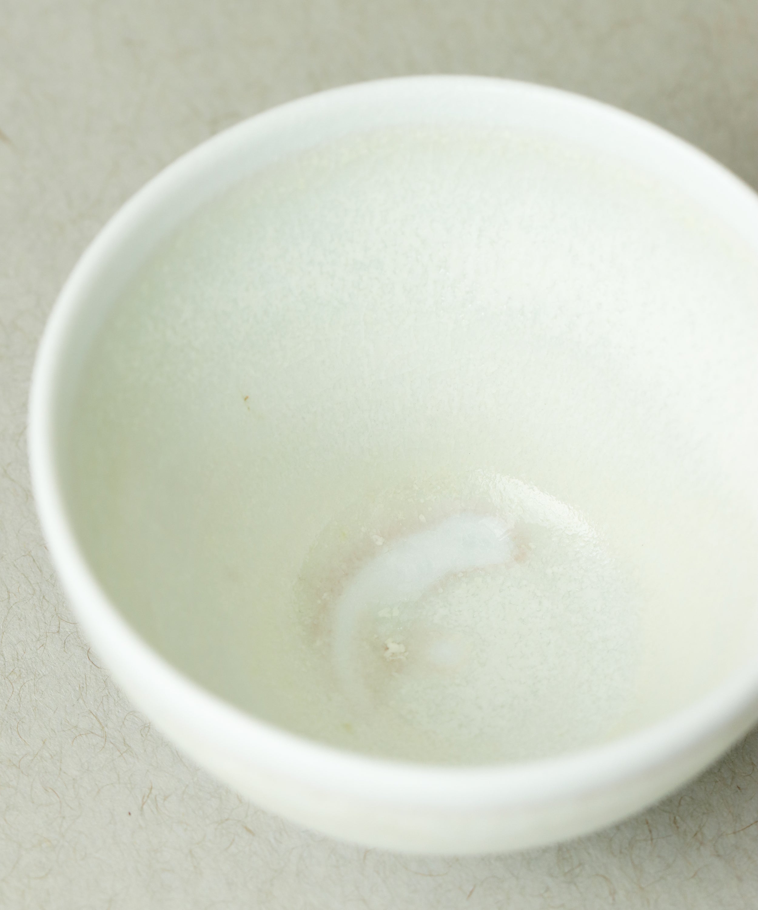 Celadon Tea Cup interior, matte yellow-green celadon glaze with kiln kiss