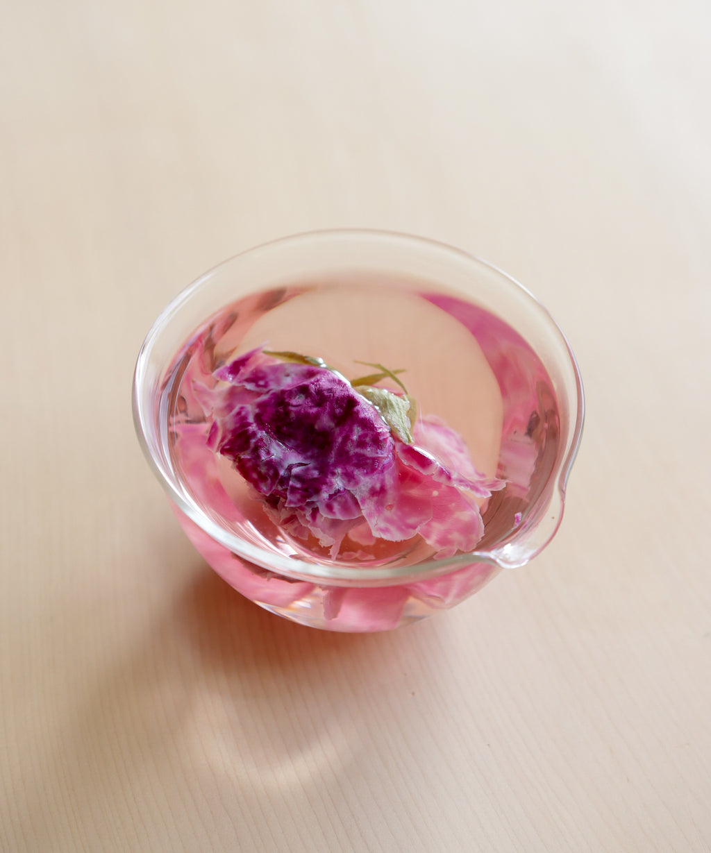 Pour of brewed crimson rose tea showing color and clarity