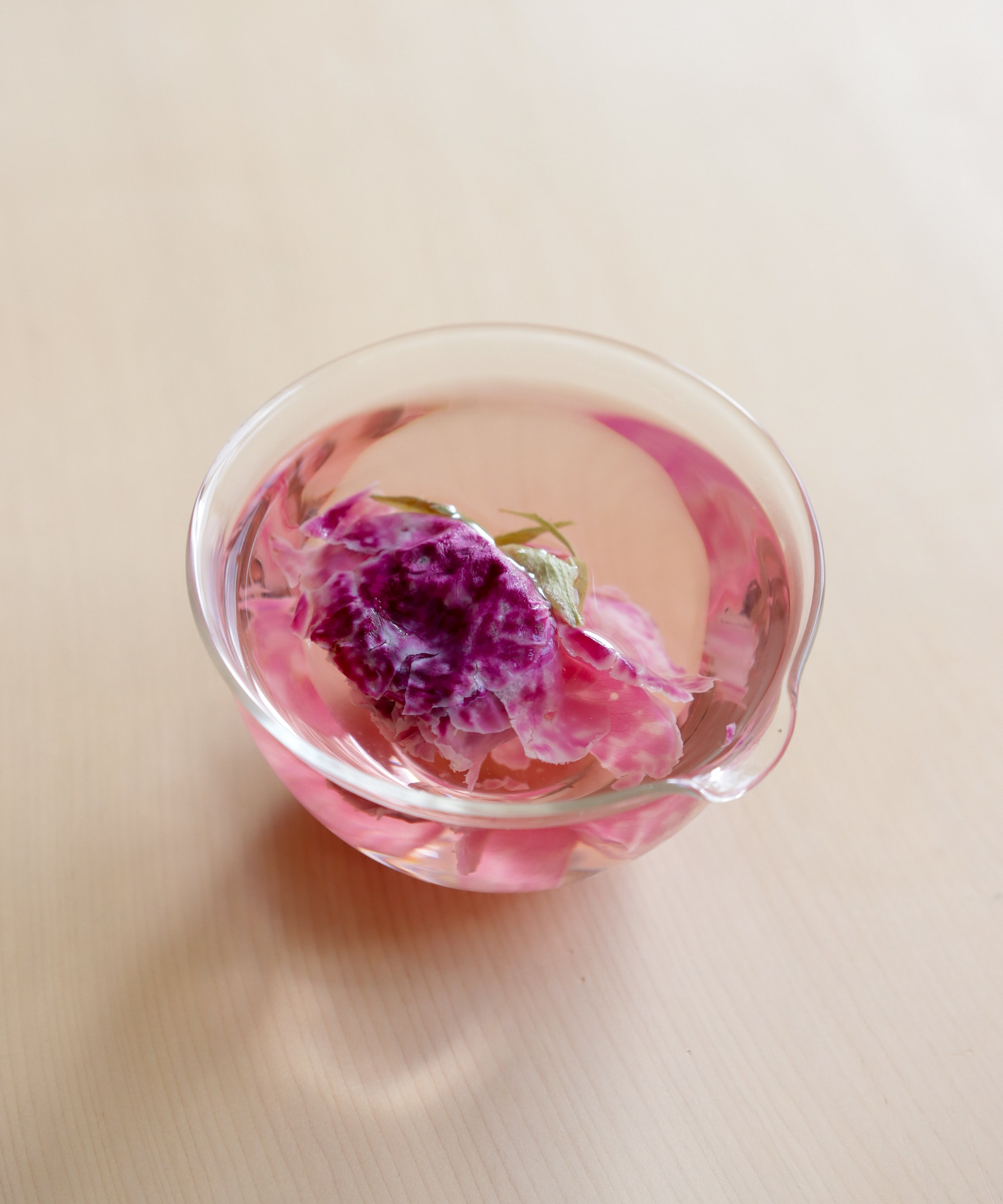 Pour of brewed crimson rose tea showing color and clarity